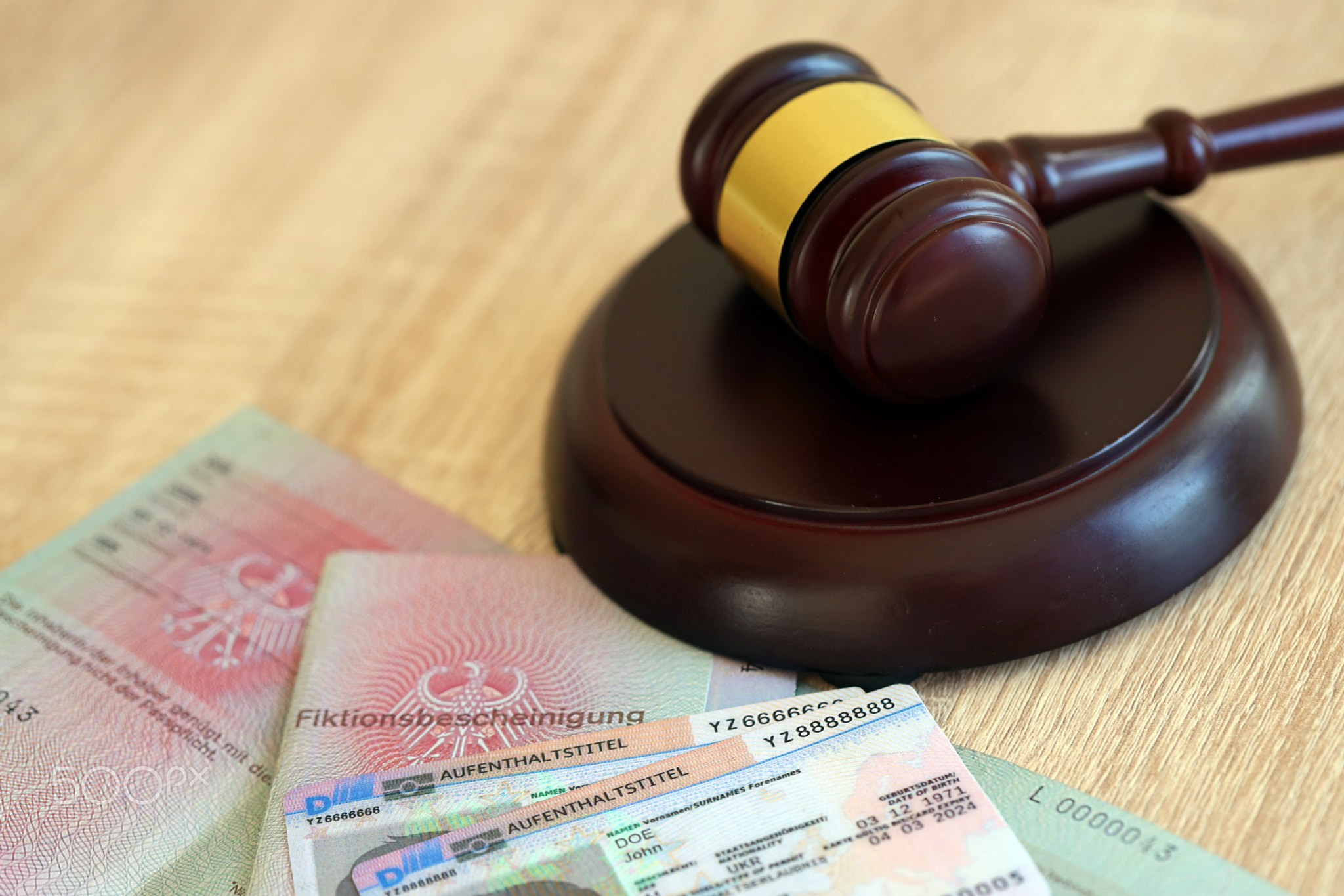 German temporary Permanent resident card lies with judge hammer. Aufenthaltstitel