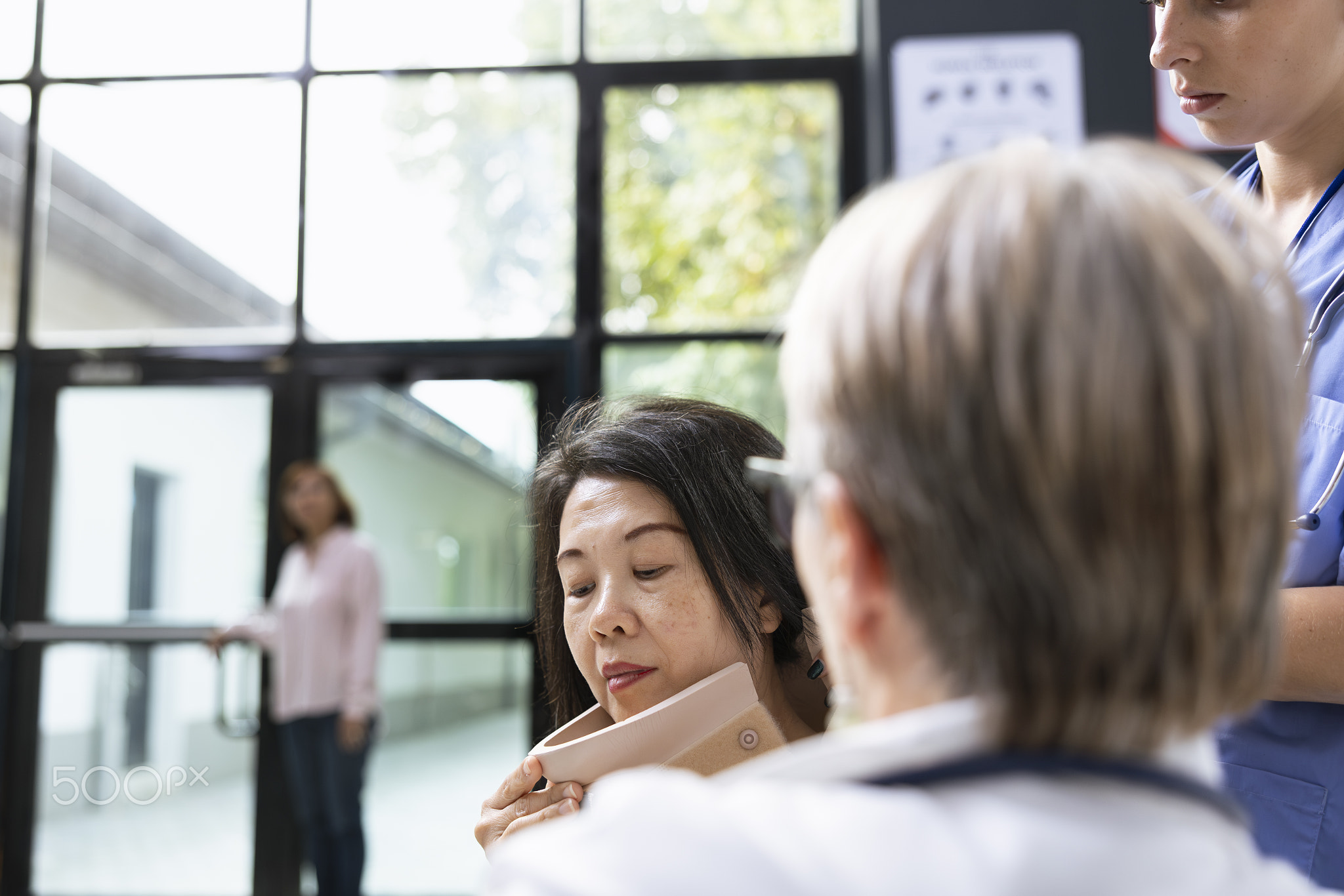 Medical professional assisting patient hurt by securing cervical support brace