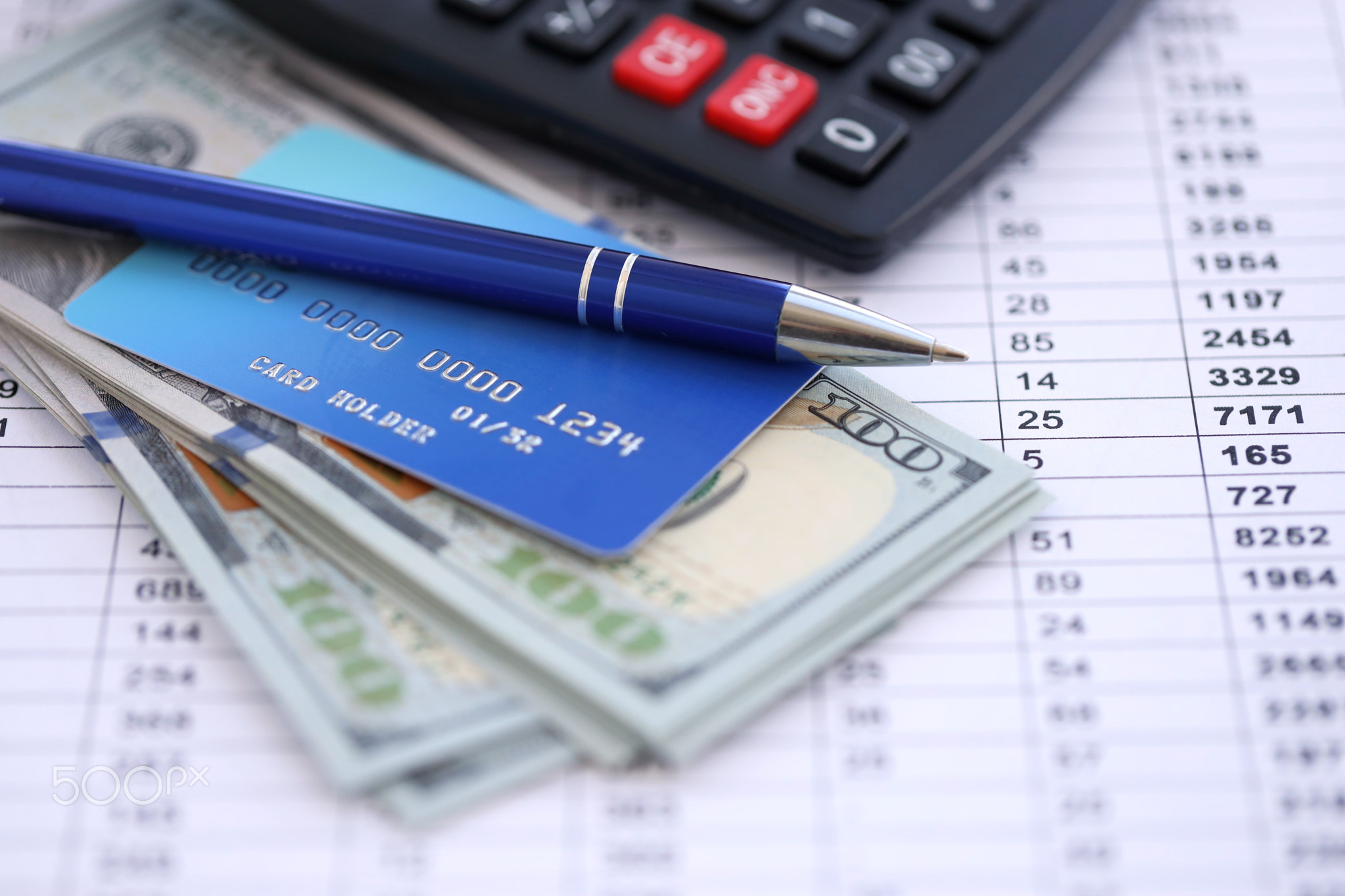Credit card and pen with US dollar currency money bills banknotes on calculations document