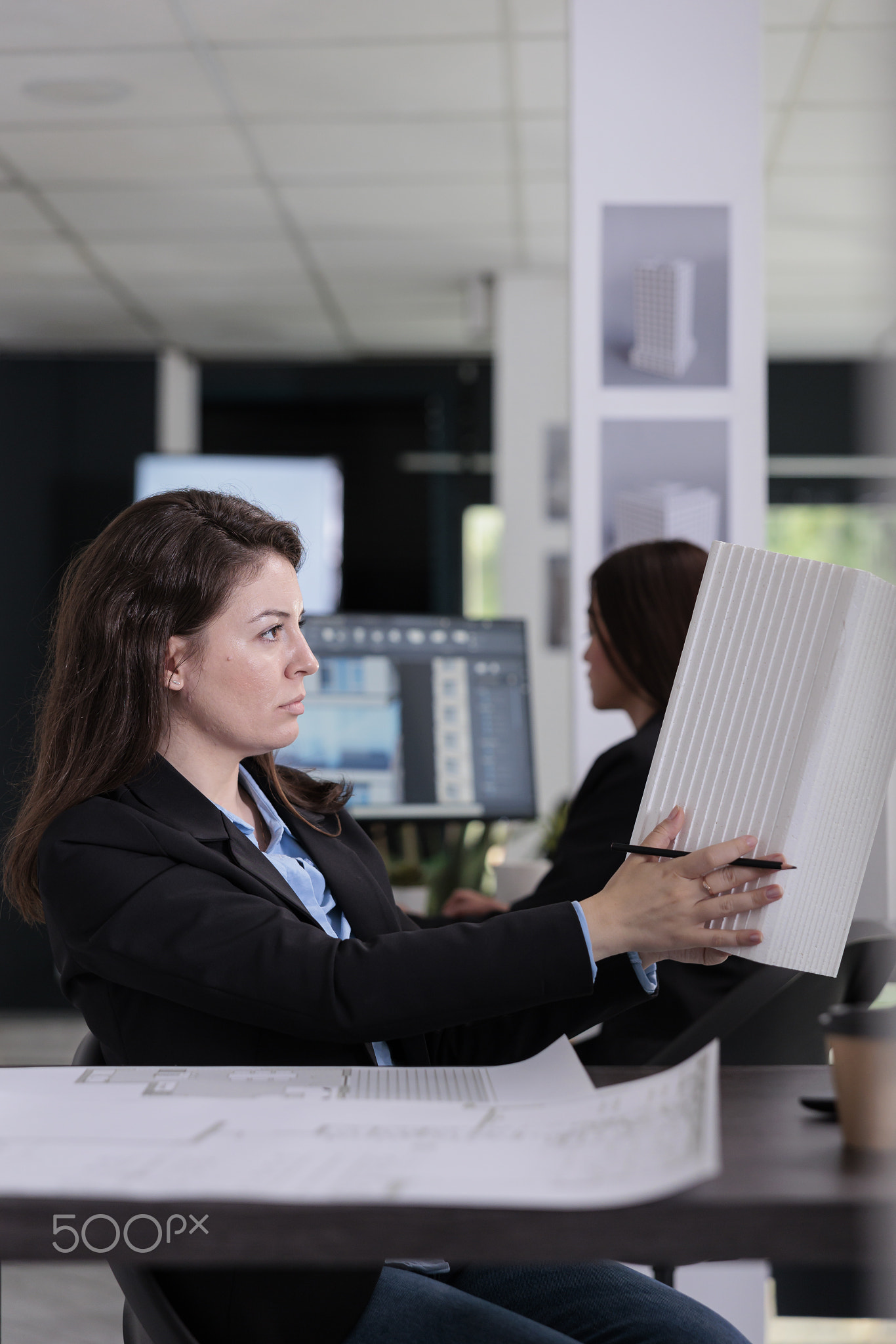 Architect holding building 3d printed model, drawing project blueprints