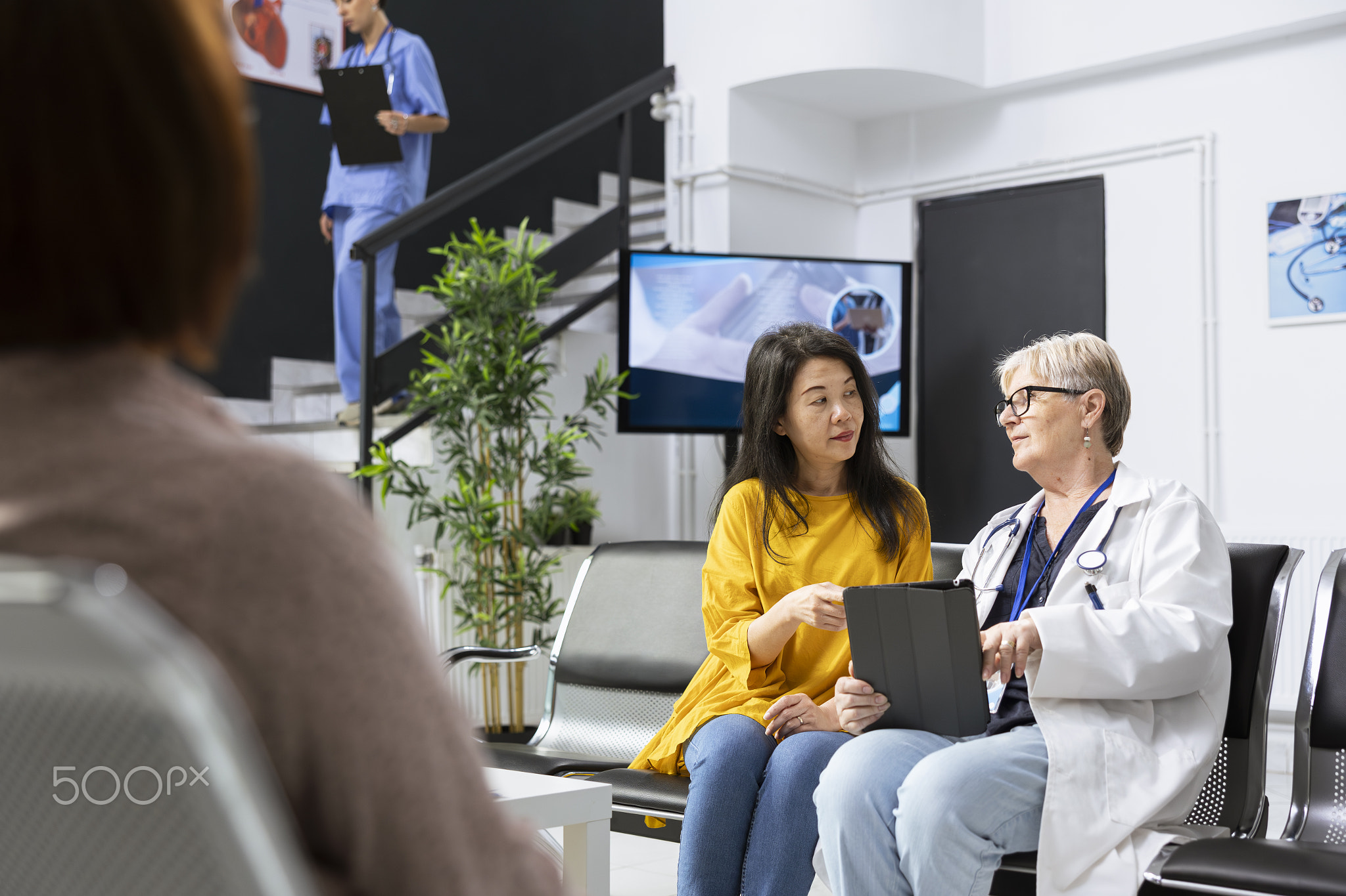 Hospital staff speaks with a patient about their medical history