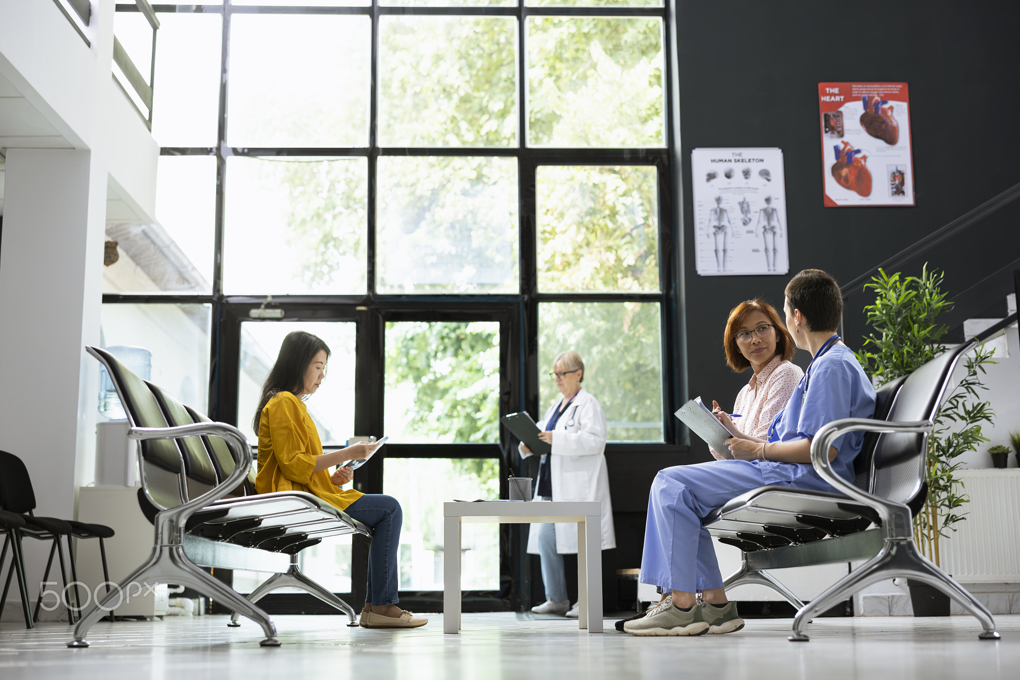 Female nurse explains medical tests and recovery steps to an asian patient