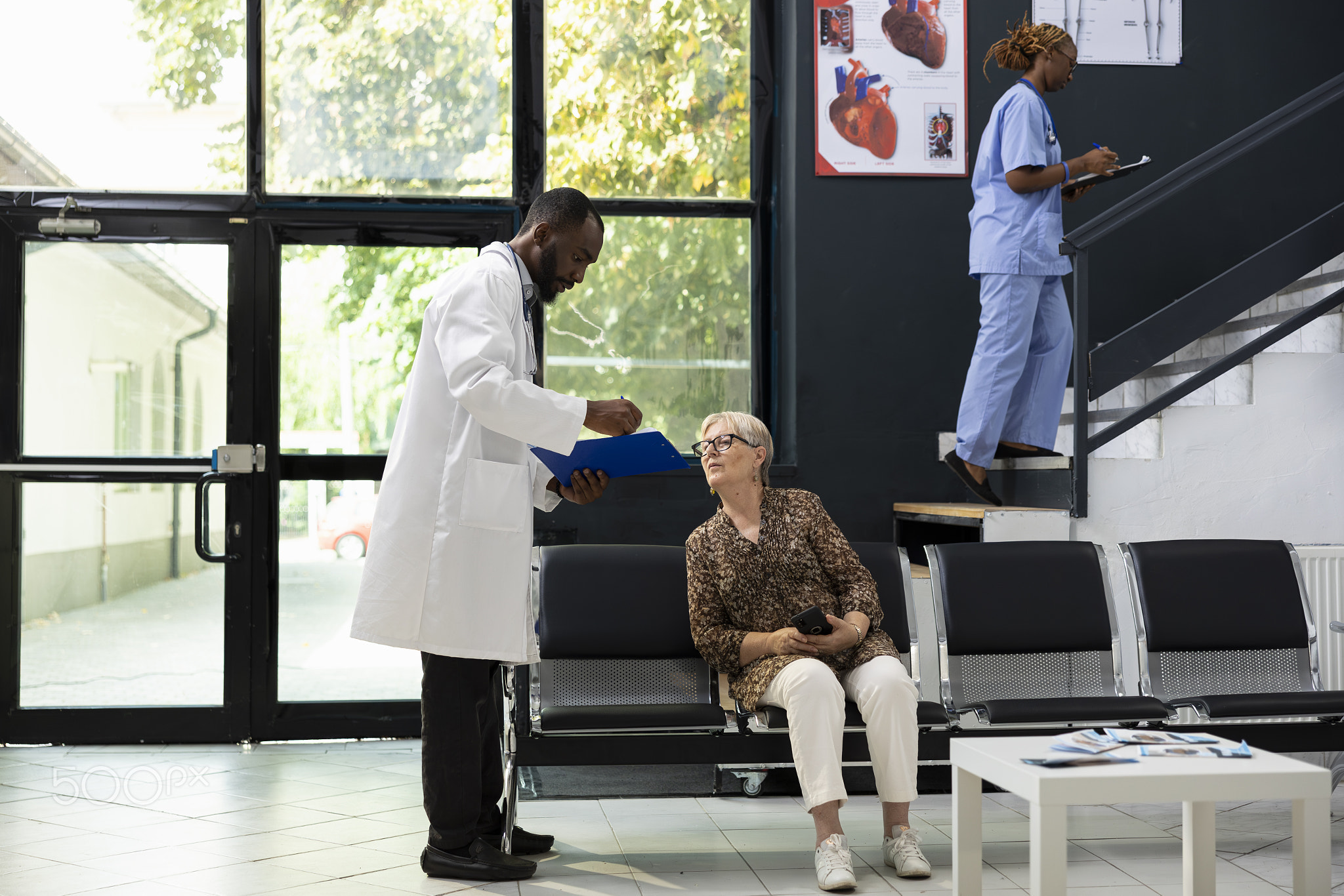 Senior patient in hospital lobby receives professional medical care