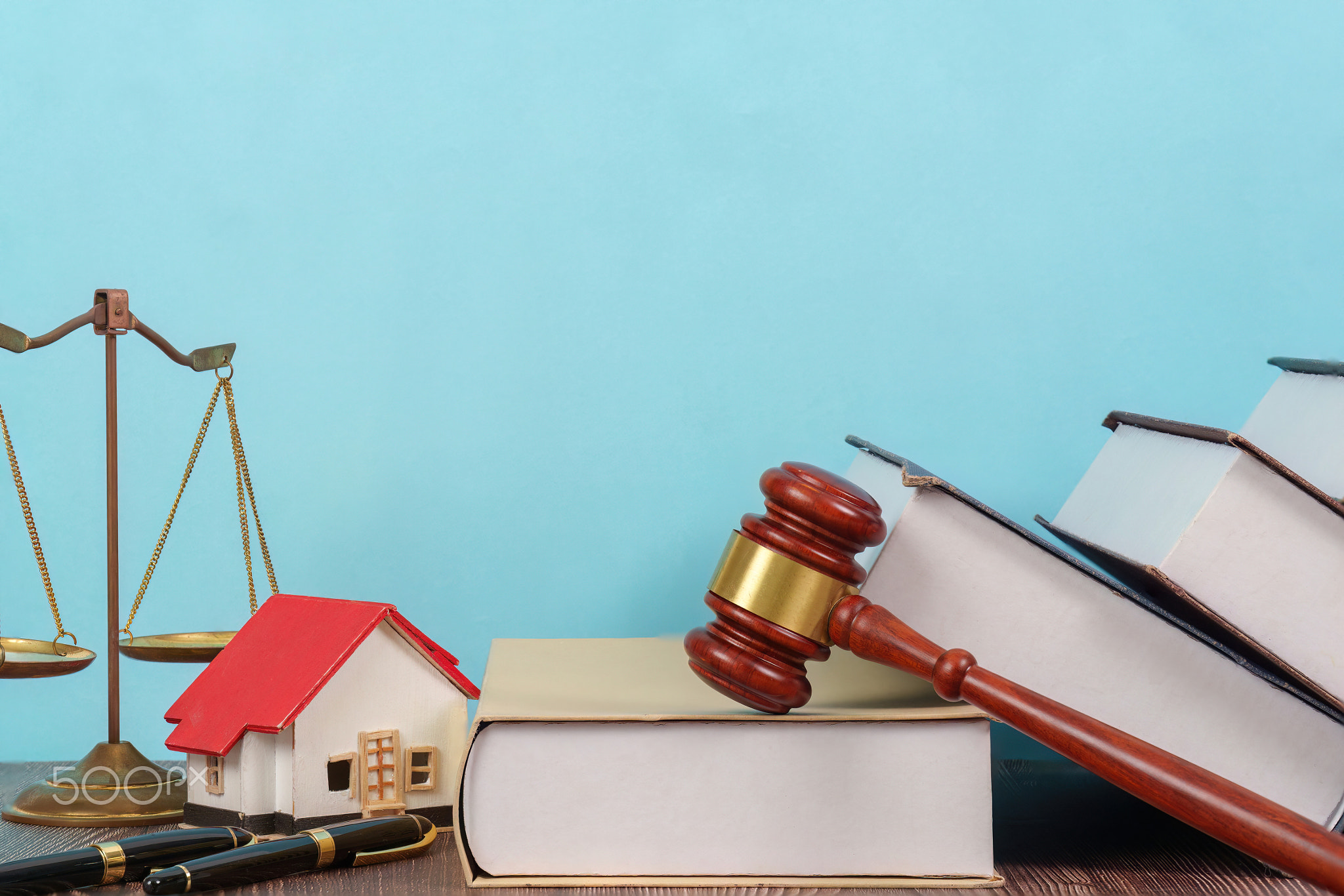Legal Background with Scales and House Model. A lawyer's desk
