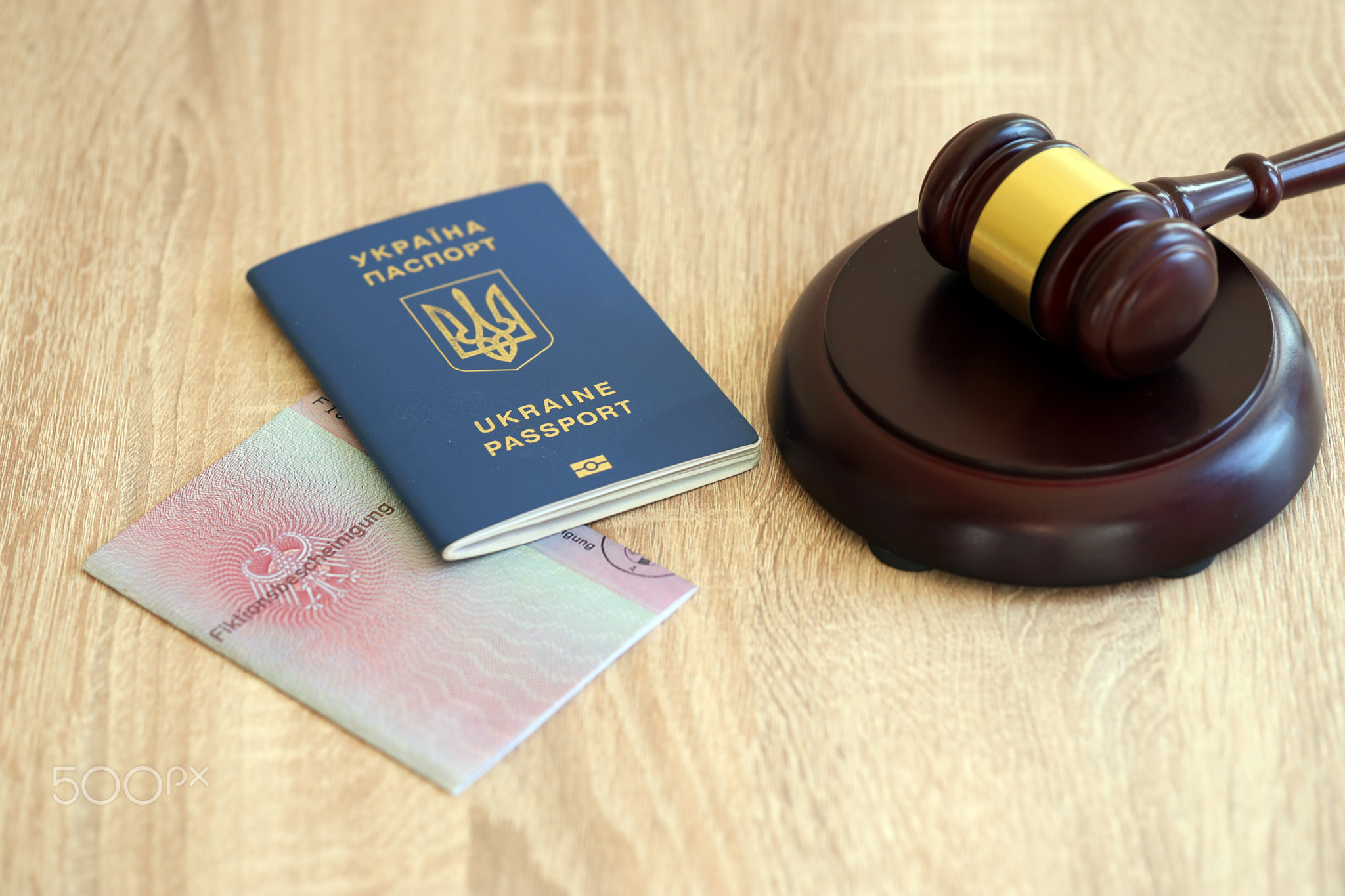 German temporary Permanent resident card and Ukrainian passport lies with judge hammer