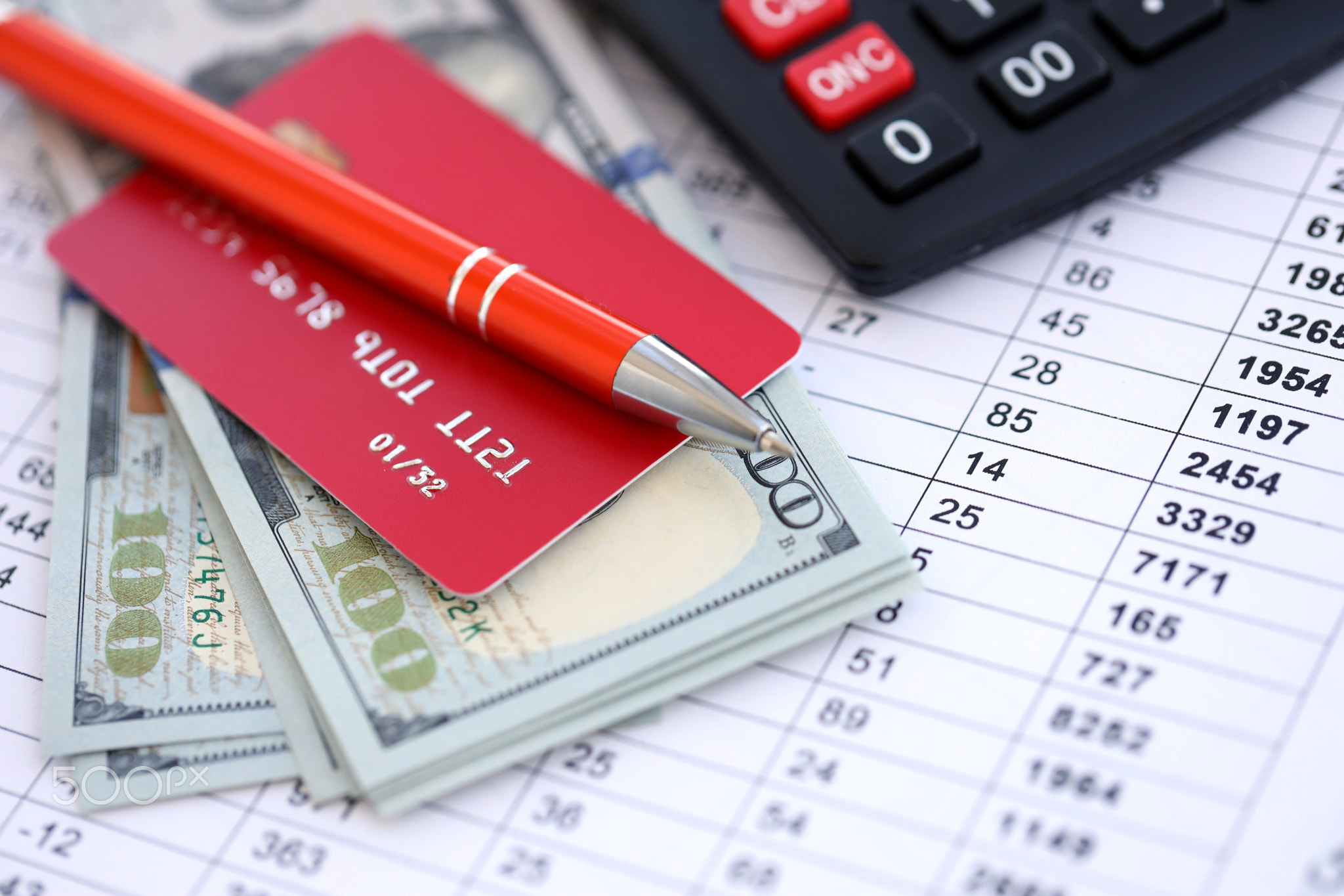 Credit card and pen with US dollar currency money bills banknotes on calculations document