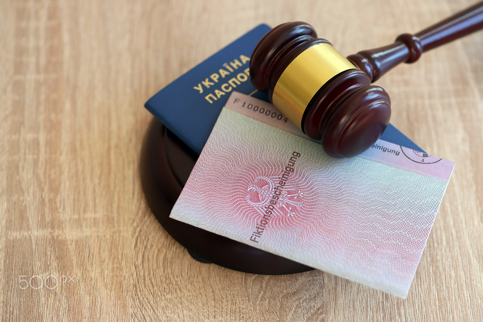 German temporary Permanent resident card and Ukrainian passport lies with judge hammer