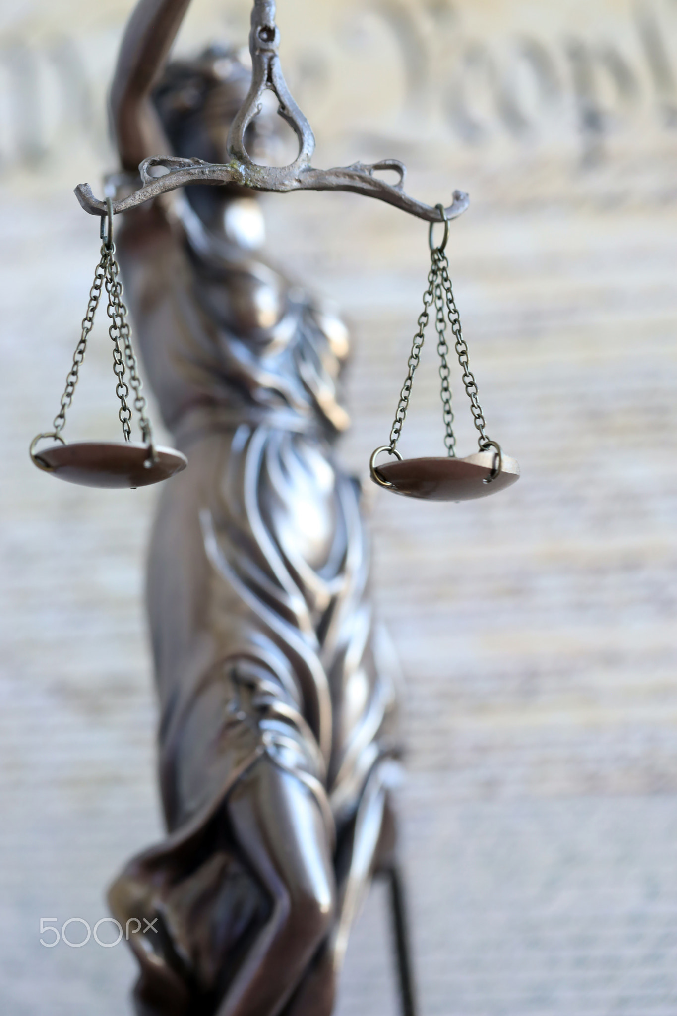 The statue of justice Themis, the blindfolded goddess of justice against US Constitution page