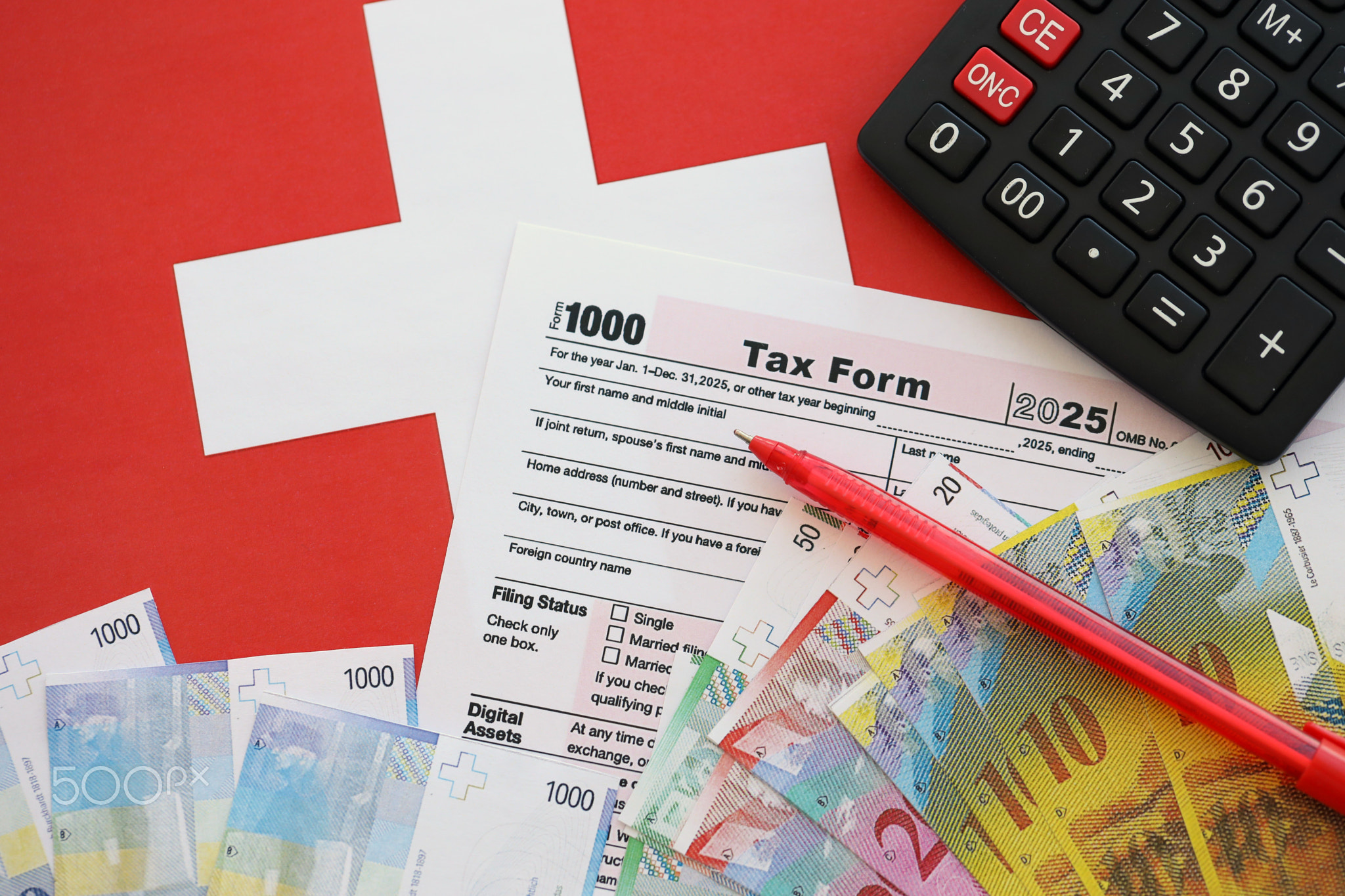 Swiss franc banknotes and tax form with pen. The current francs money bills lies on tax return form