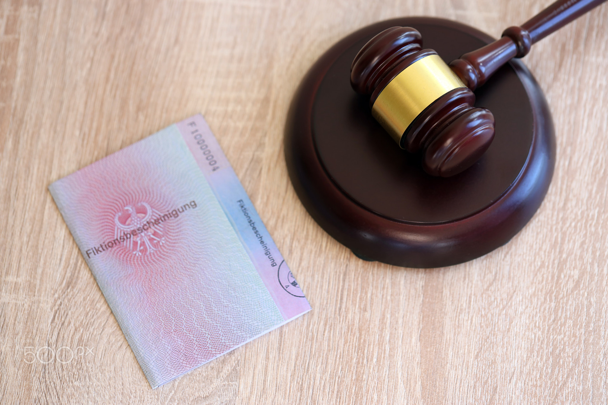 German temporary Permanent resident card specimen lies with judge hammer. Fiktionsbescheinigung