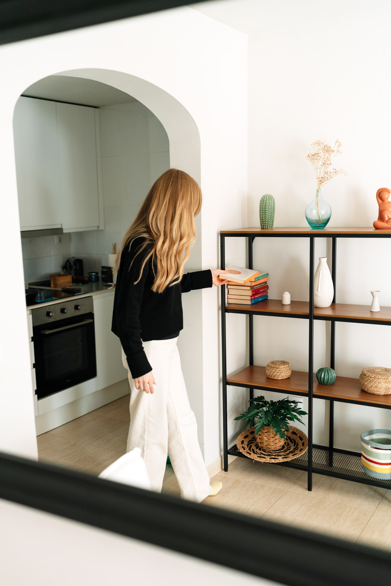 Midsection of woman choosing a book at home