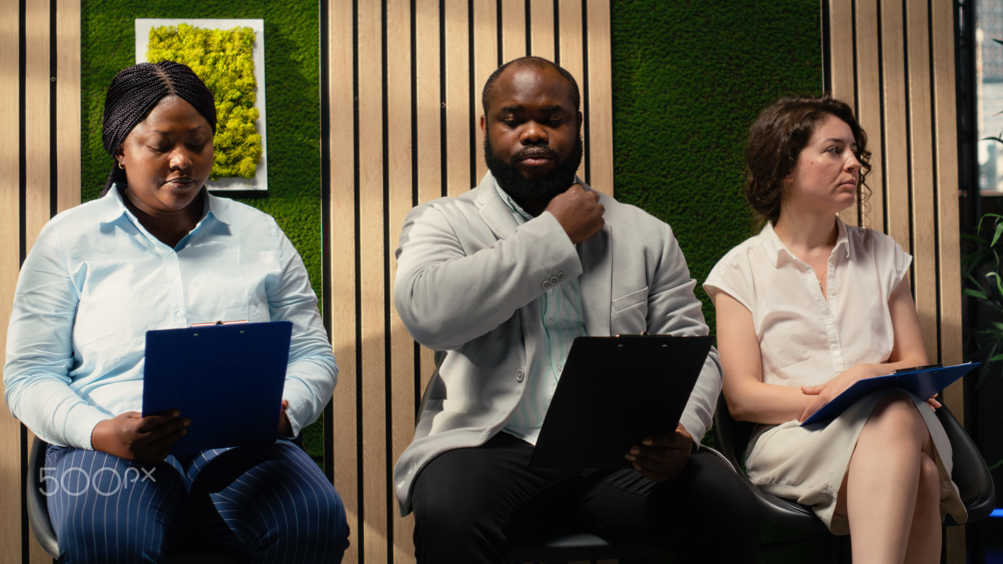 Multiethnic job seekers waiting in the corridor with their CV files