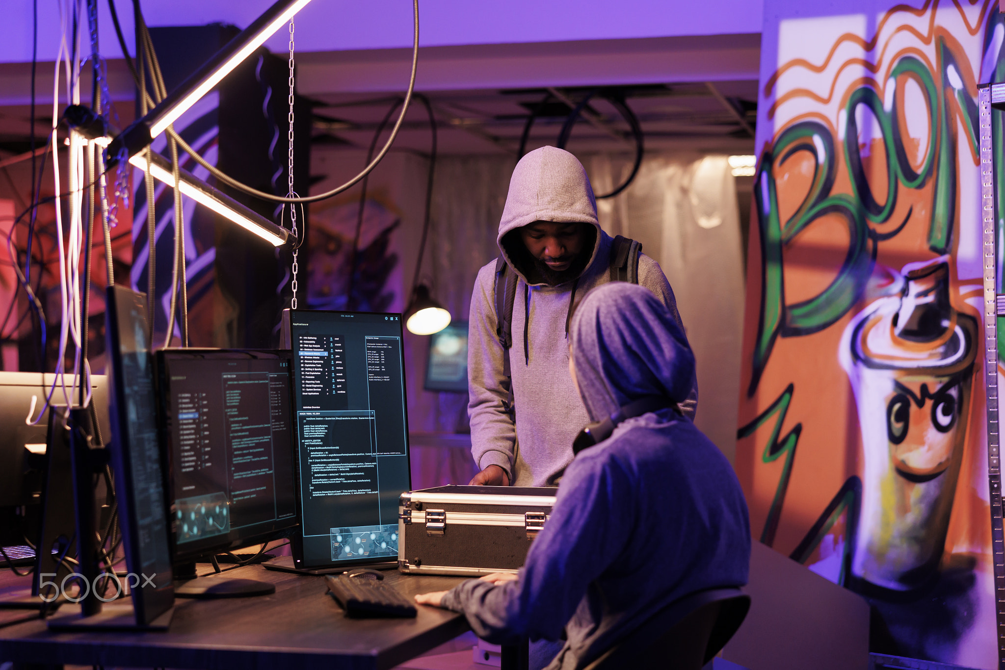 Hacker in hood showing black box