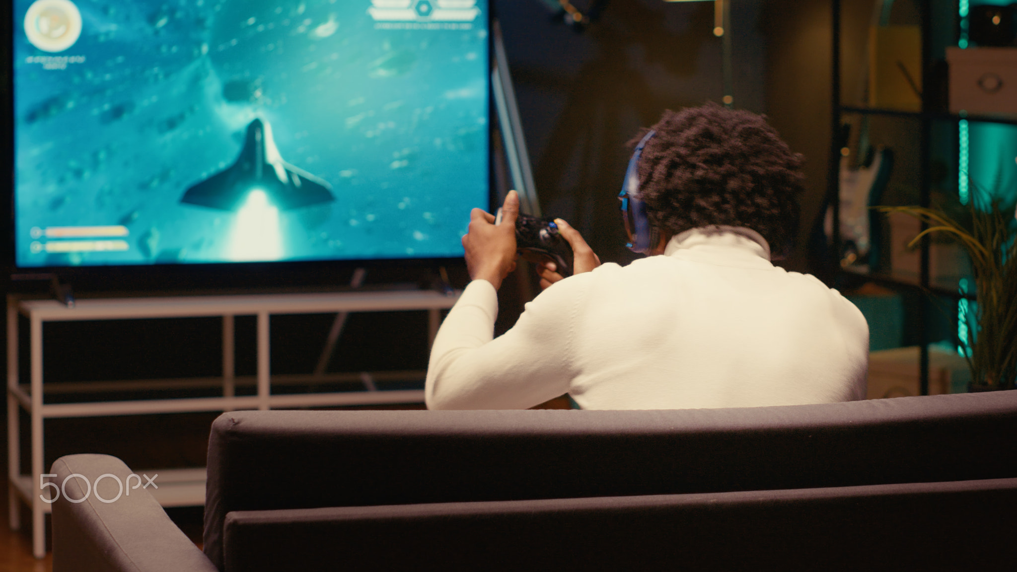 Player in home theatre enjoys game with spaceship shooting laser streams using crosshair overlay