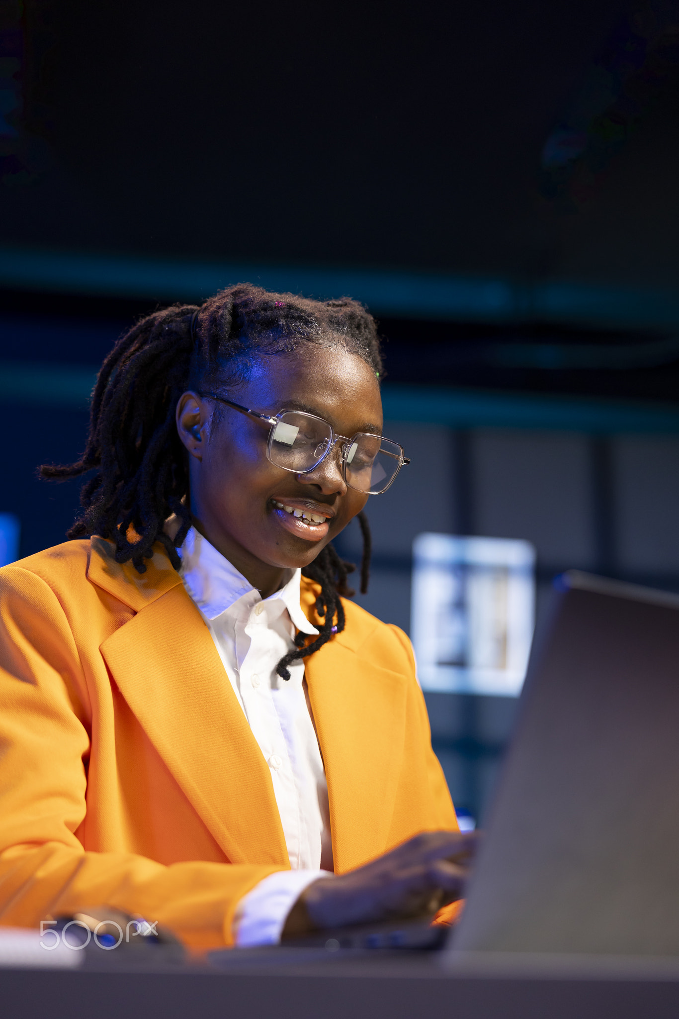 Smiling woman using laptop and mouse in home office to solve various work tasks