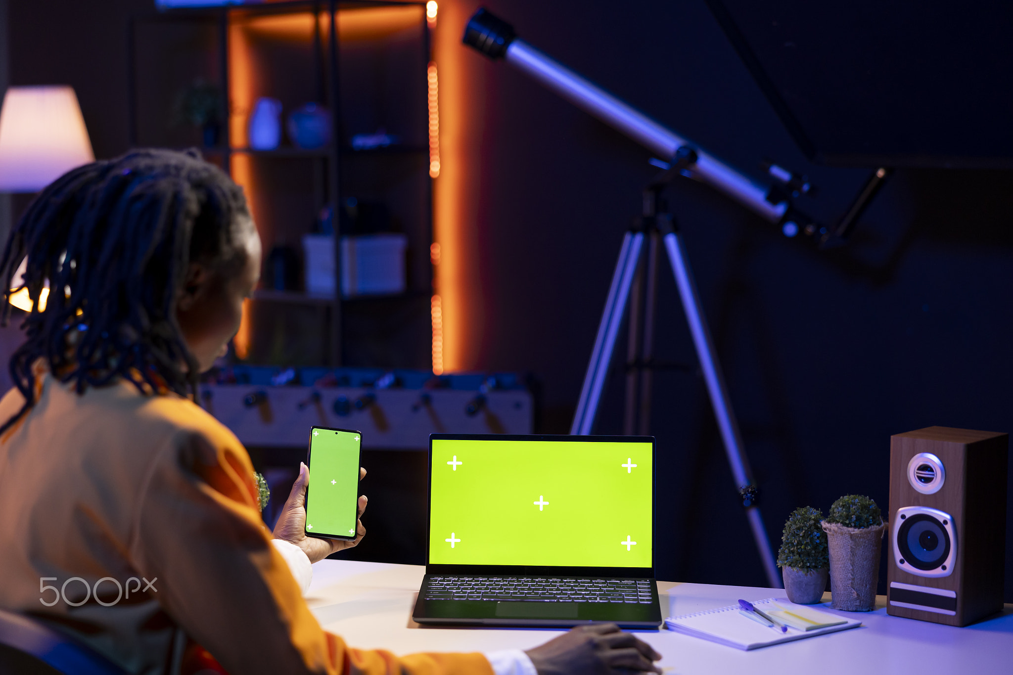 Woman in home office watching videos on social media using green screen laptop