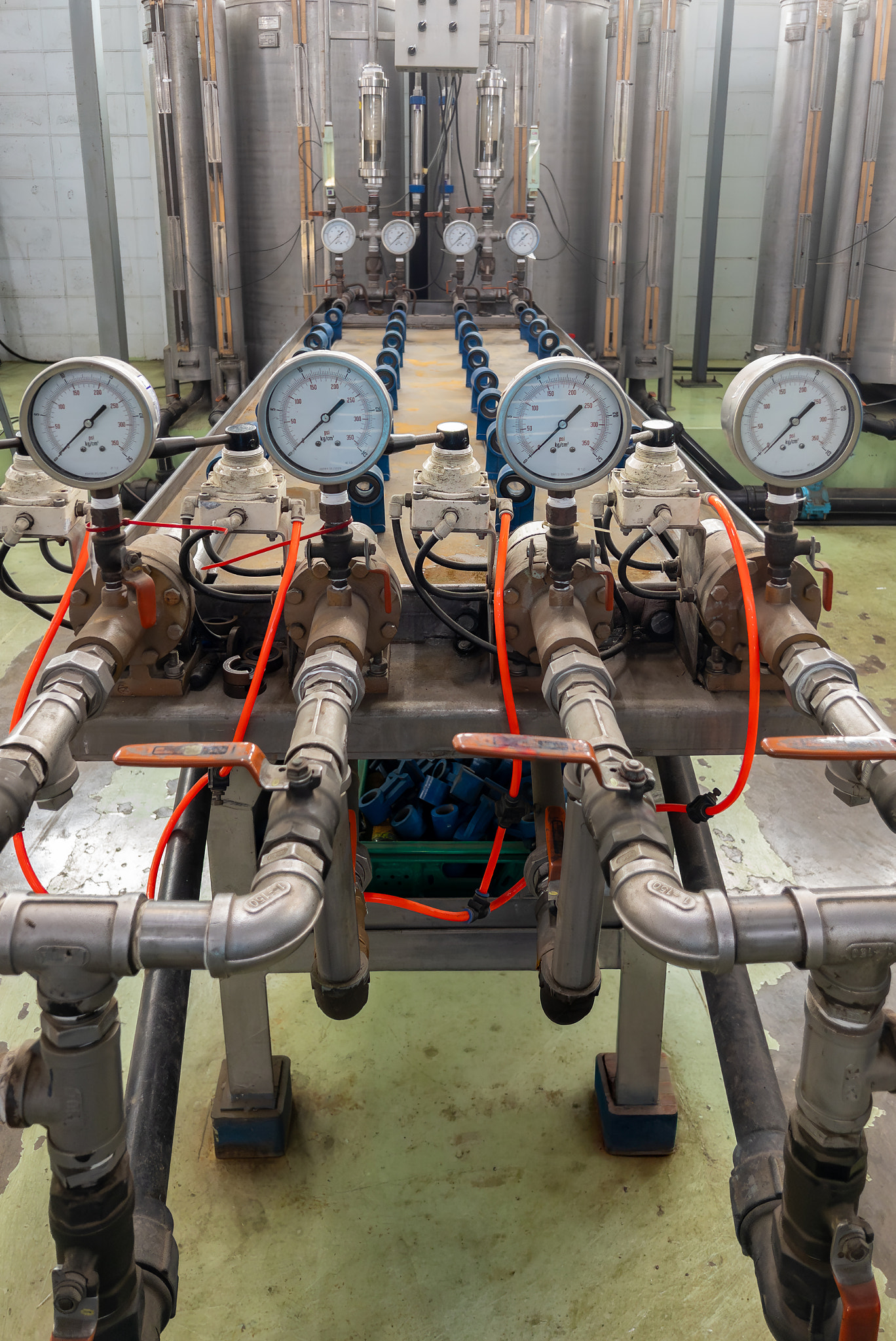Industrial water filtration system with pressure gauges and pipes.
