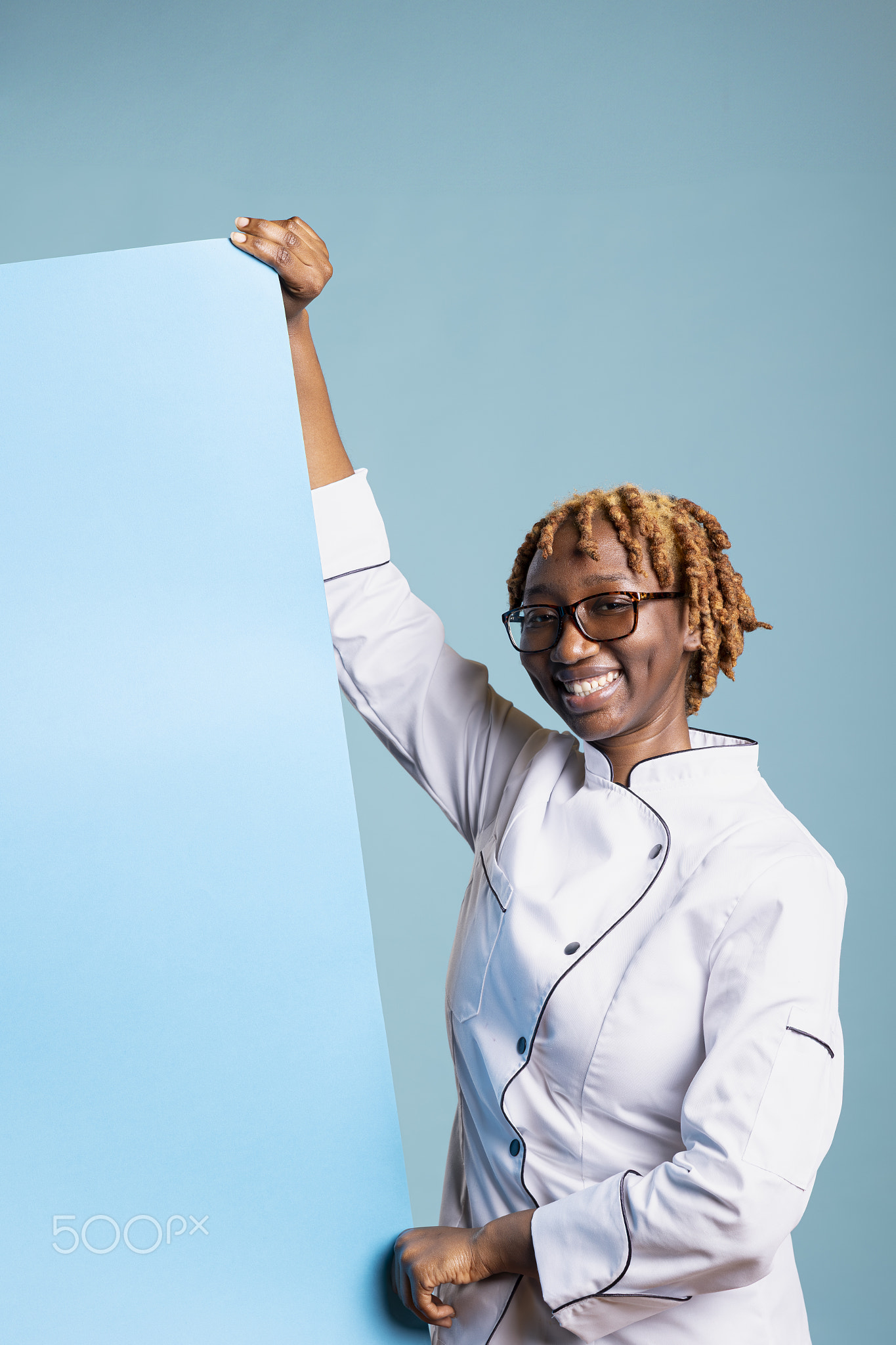 Cheerful Female Chef Holding Blank Blue Poster