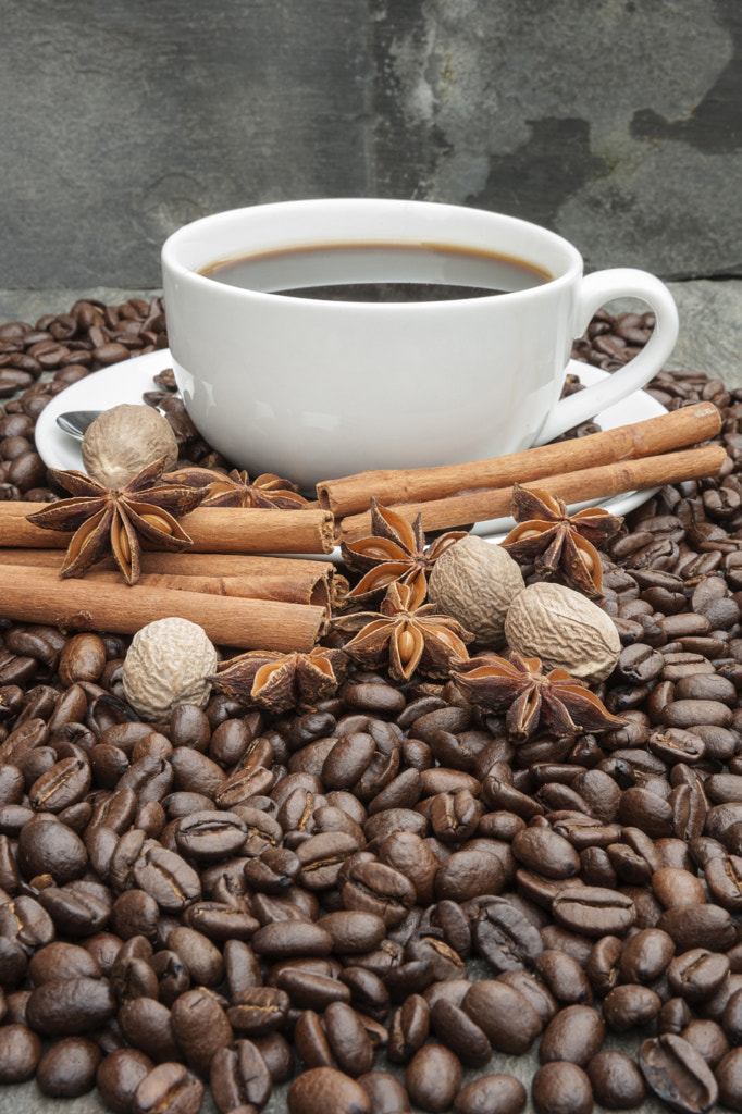 Cup of coffee with cinnamon, star anise, nutmeg and coffee beans by Matt Gibson / 500px