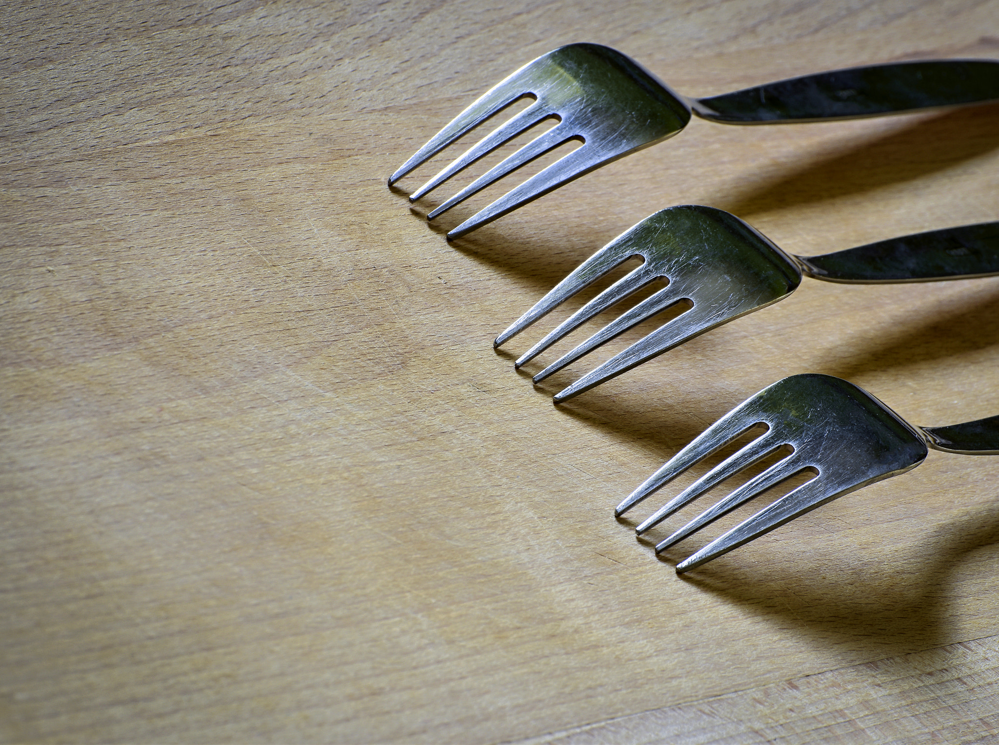 Three forks on a wooden board