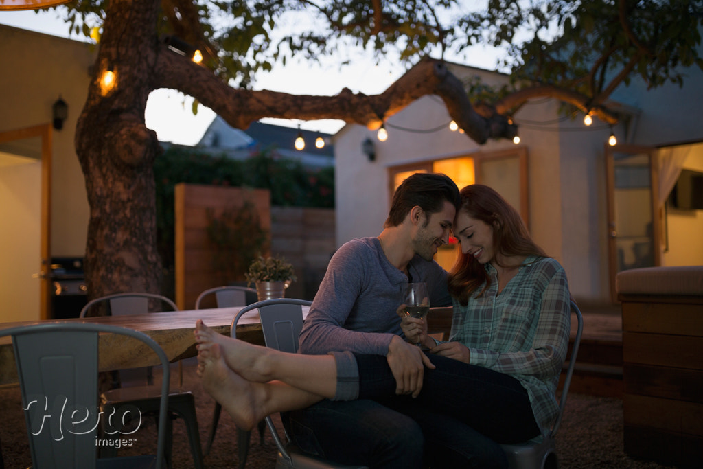 Affectionate couple relaxing drinking wine on patio