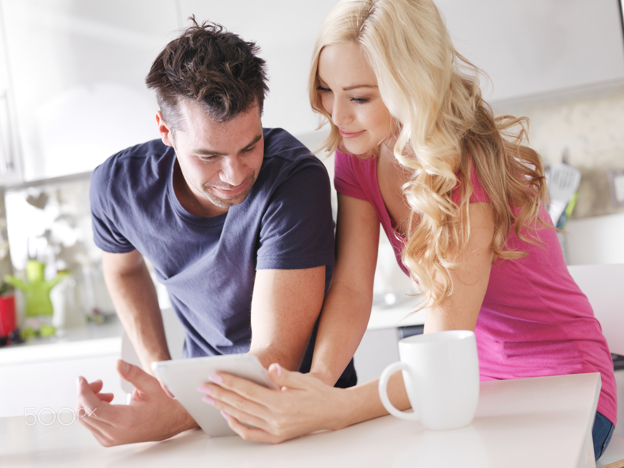 couple using tablet pc to shop online in kitchen