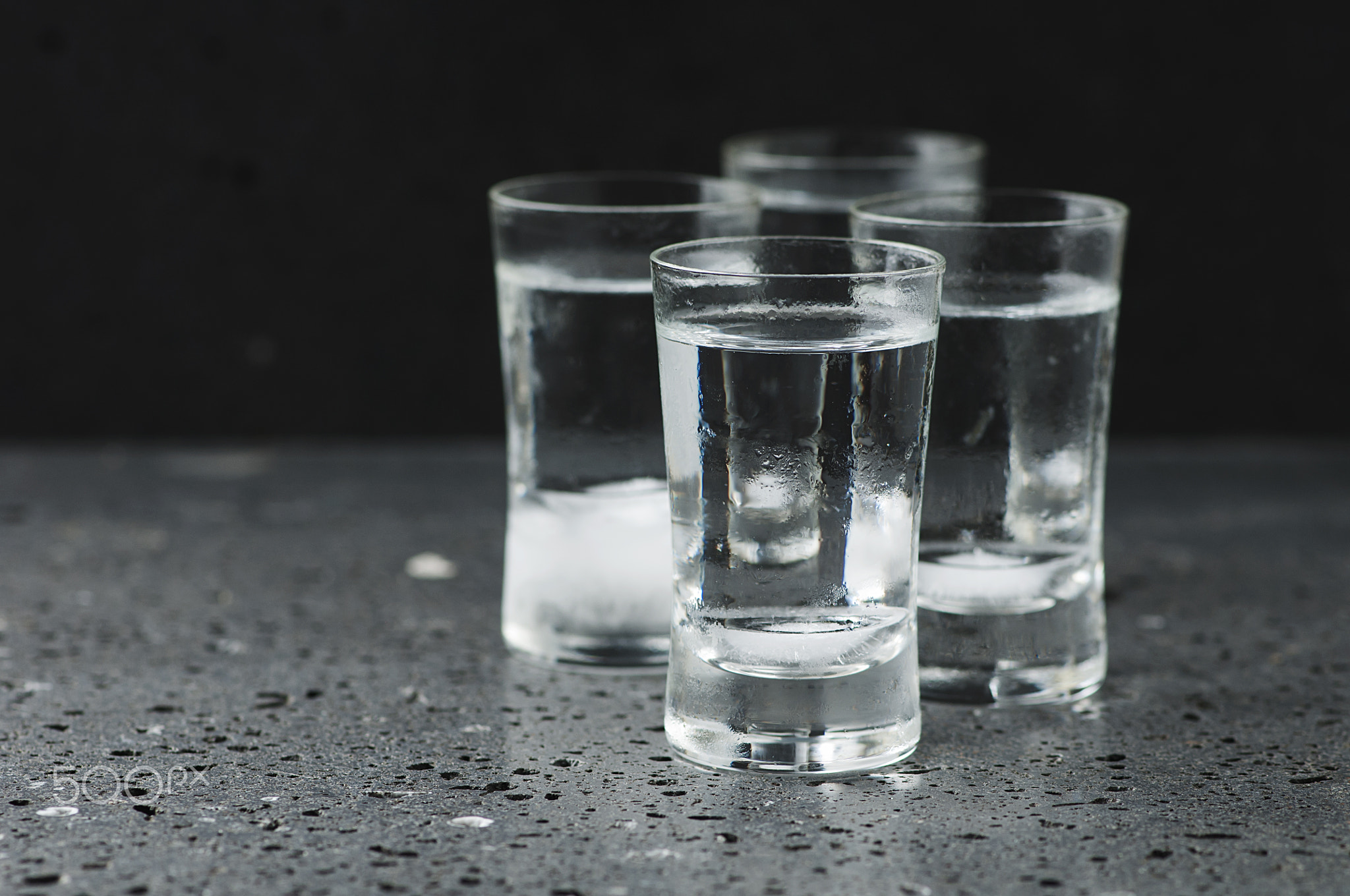 A glass of vodka on the black table