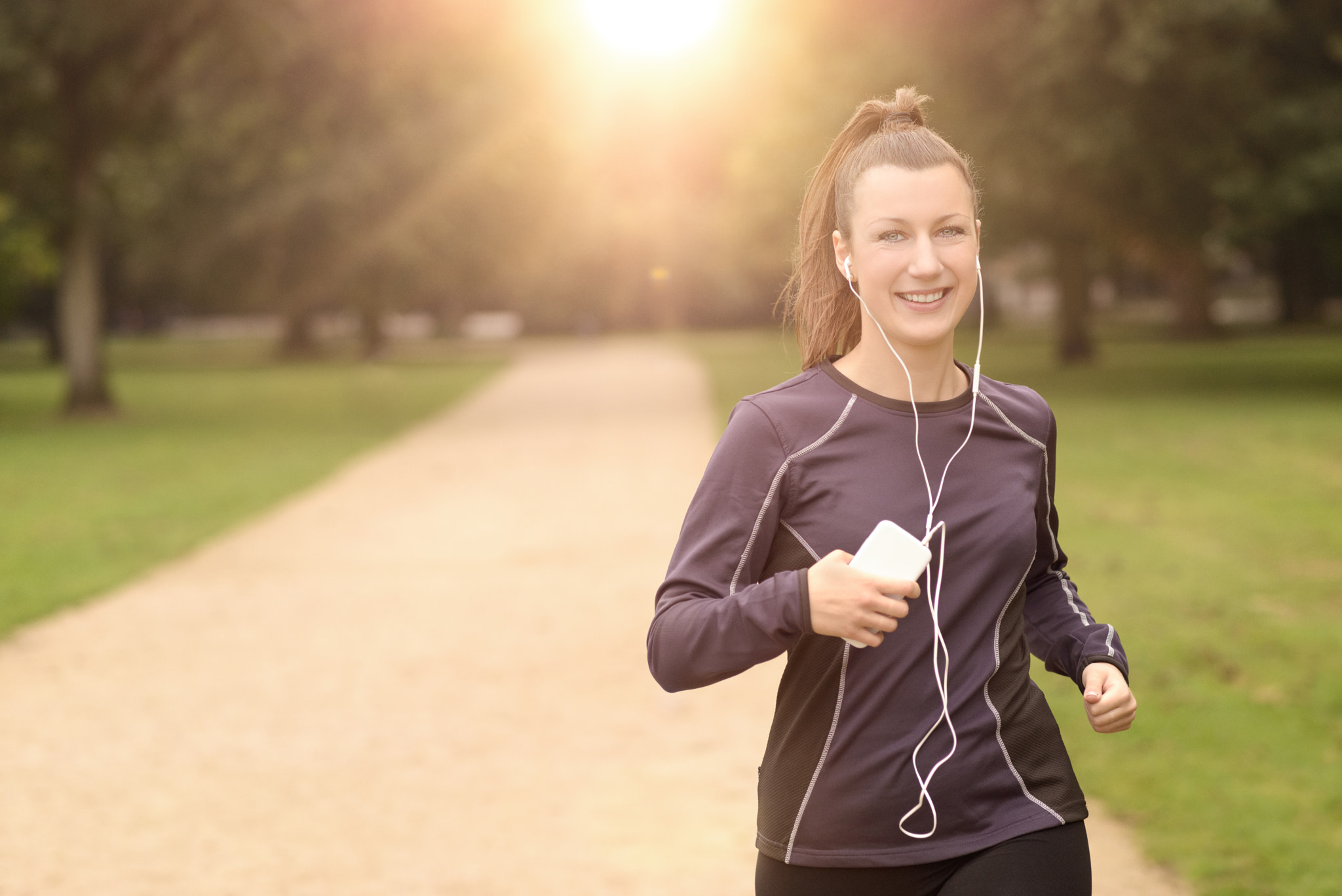 Pretty Woman Jogging at the Park with Headphones
