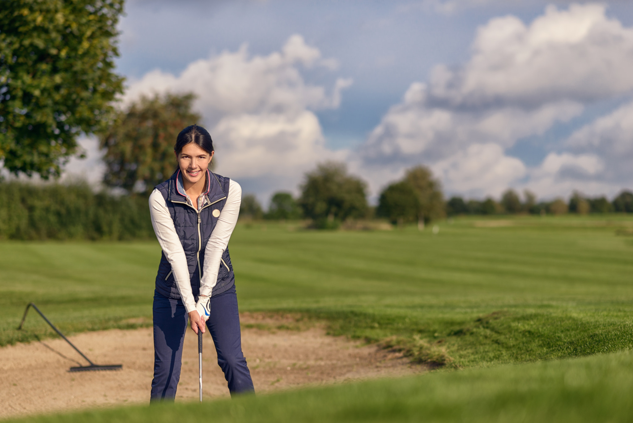 Young woman golfer in a sand bunker