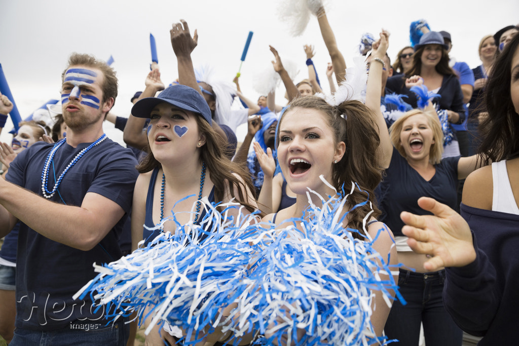 Enthusiastic crowd in blue cheering at sports event