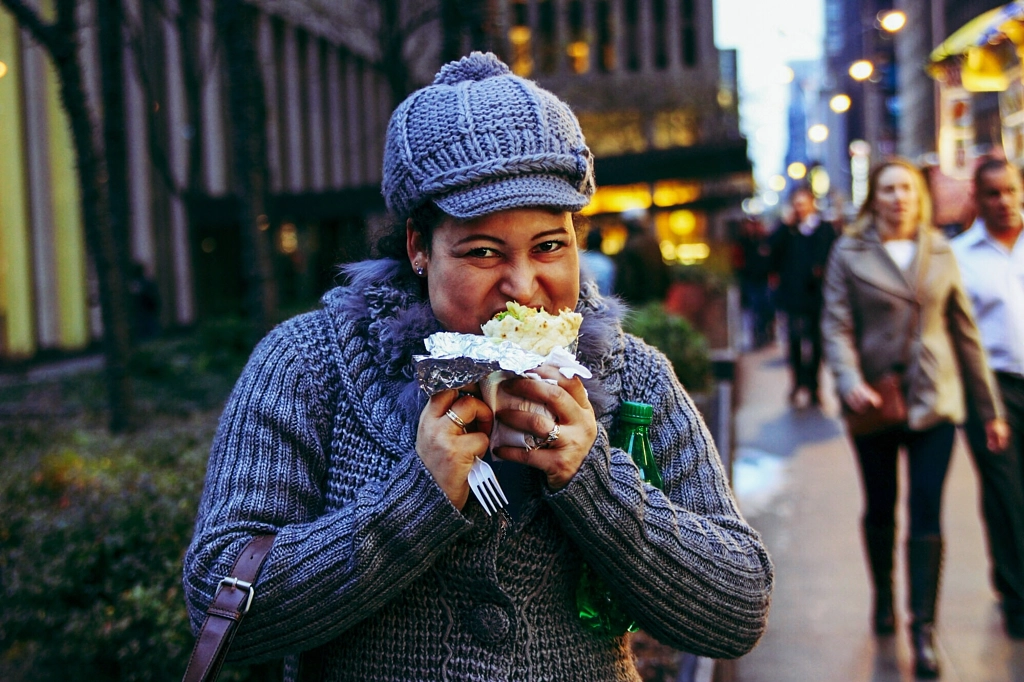A woman unabashedly enjoys a quick meal-on-the-go in Manhattan, New York. by Roxana Maza on 500px.com