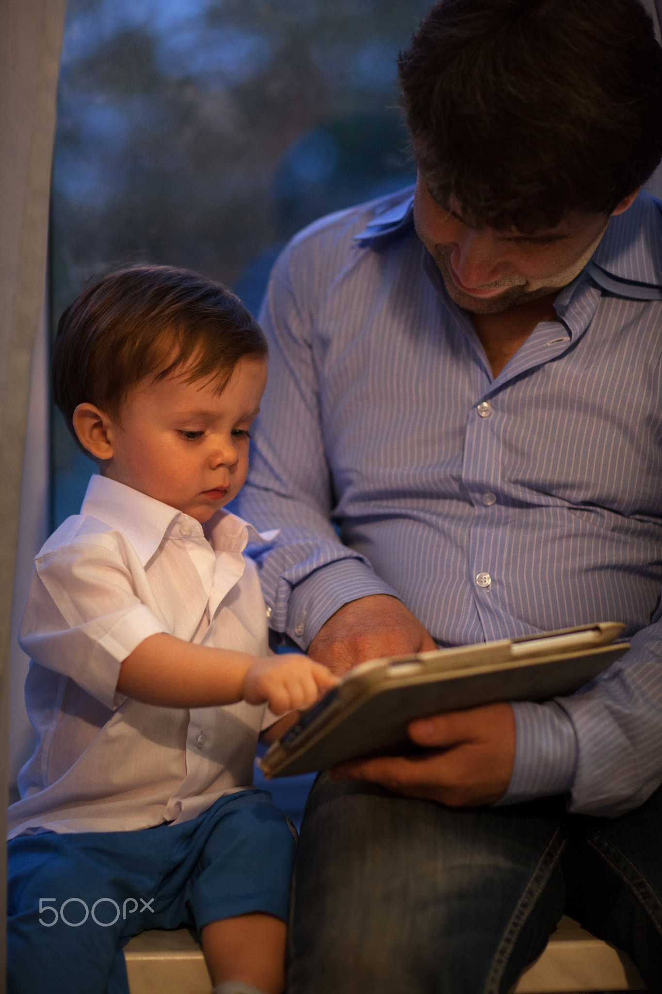 Man and little boy playing with tablet