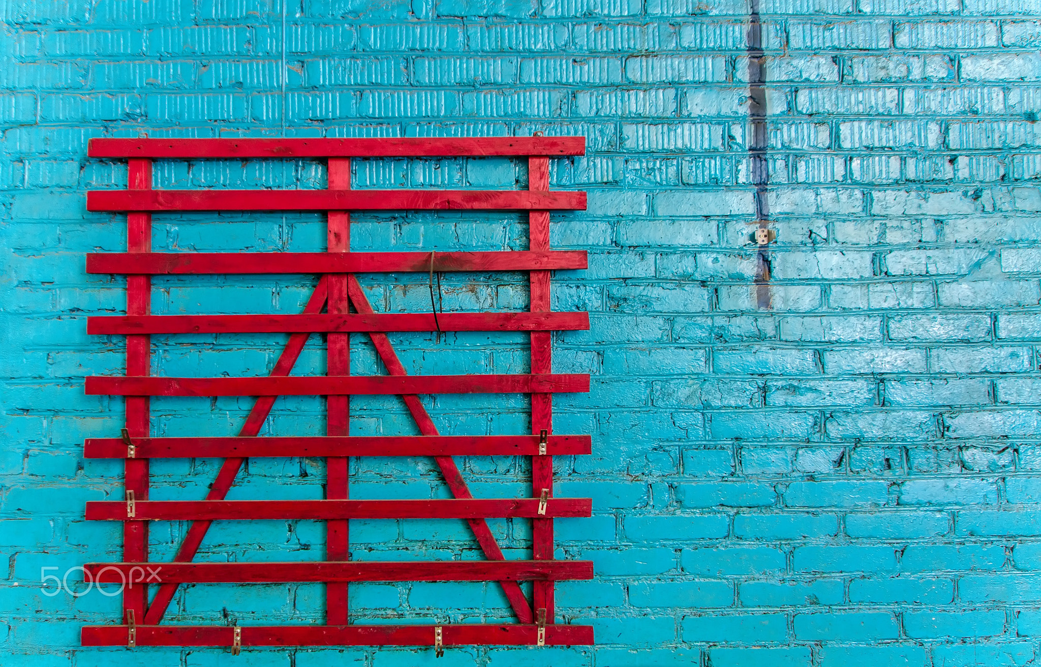 Blue brick wall with red wooden grid