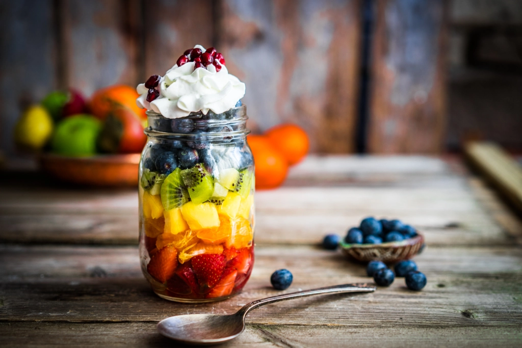 Colorful fruit salad in a jar on rustic wooden background by Alena Haurylik on 500px.com