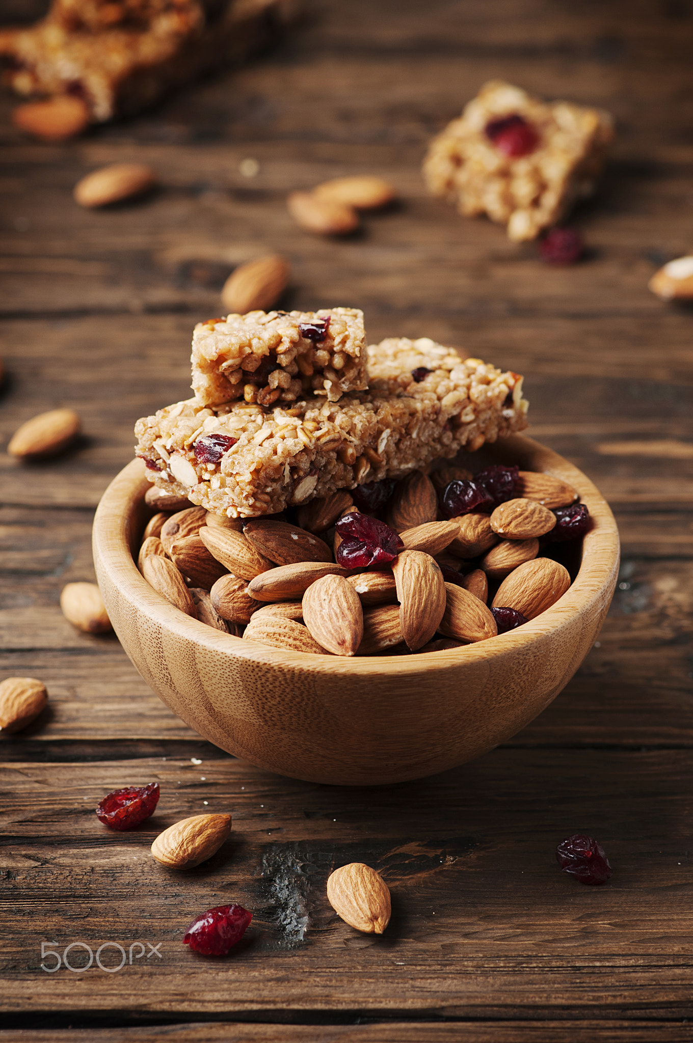 Cereal bar with almond and berry on thw wooden table