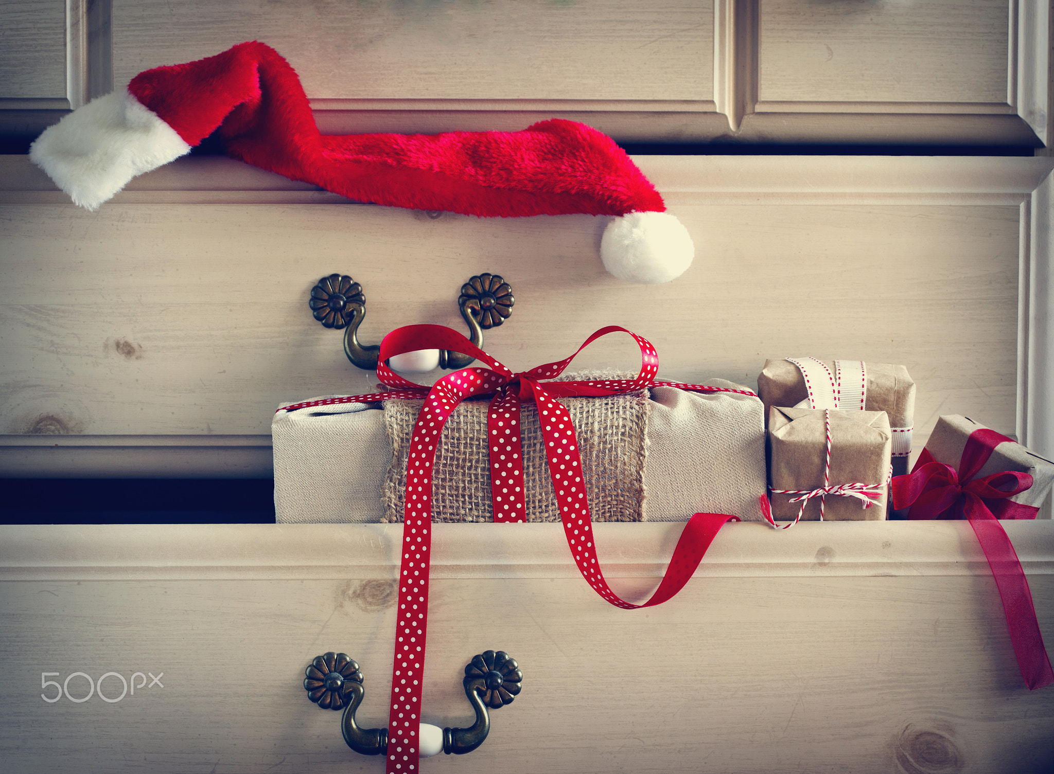 Christmas gift and Santa Claus hat in dresser drawer