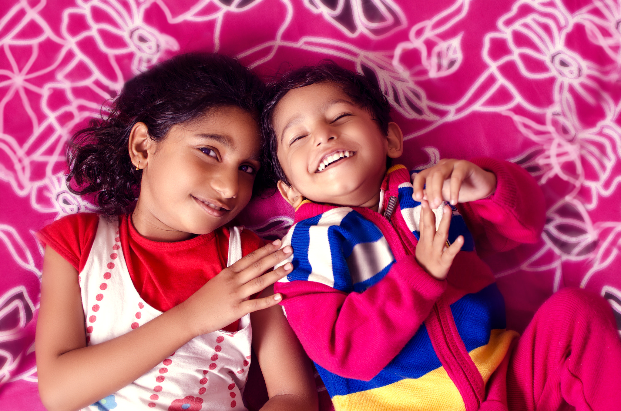 brother sister siblings playing on bed