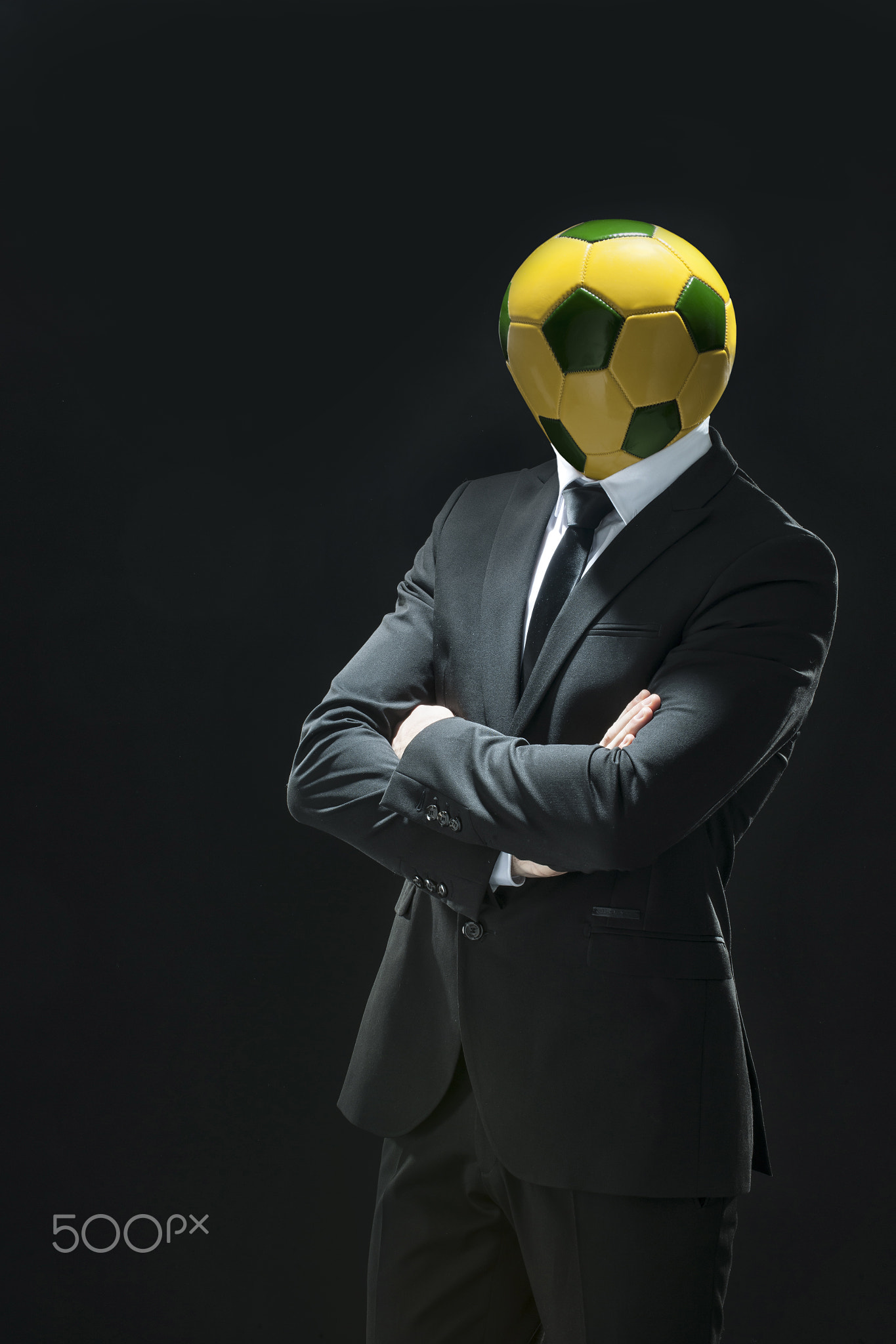 man in suit on black background with a soccer ball instead of th