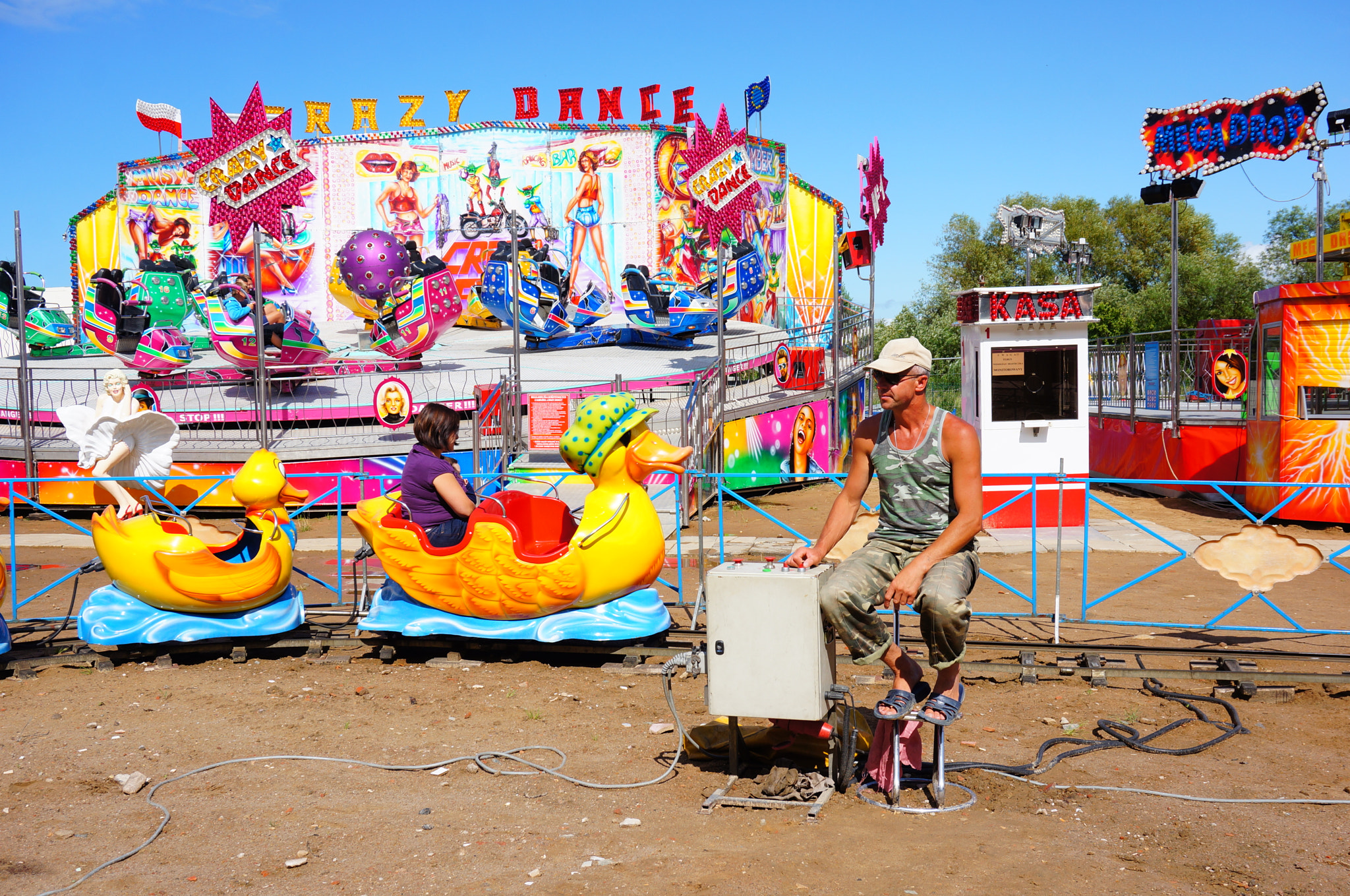 Sony Alpha NEX-5N + Sony E 18-50mm F4-5.6 sample photo. Man controlling a duck train on track attraction at a fair in ustronie morskie, poland photography