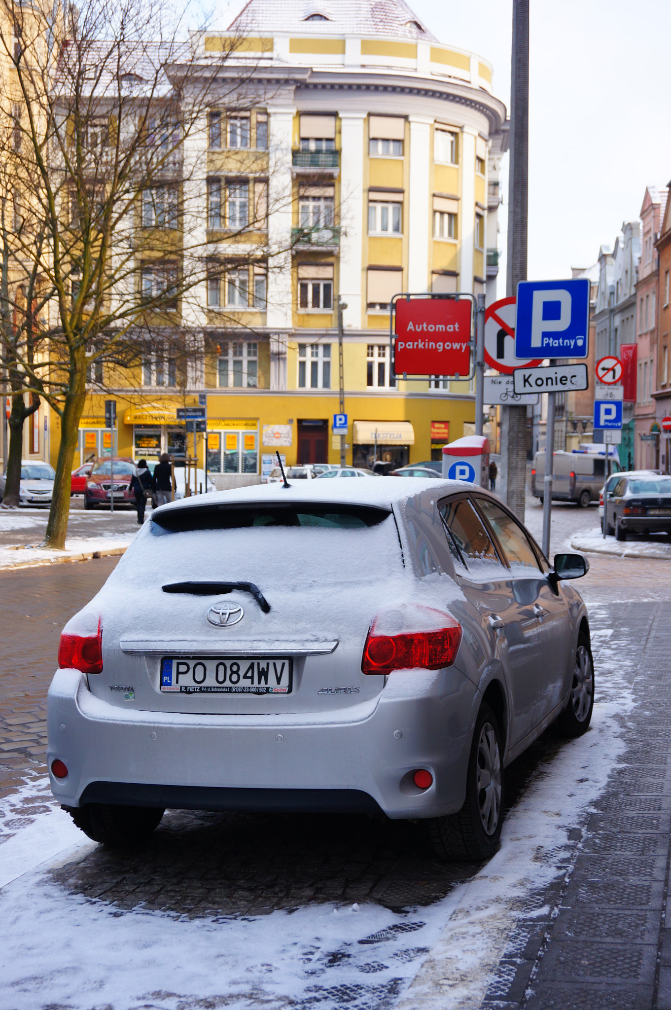 Sony Alpha NEX-5N + Sony E 18-50mm F4-5.6 sample photo. Poznan, poland - january 26, 2014: car parked by a parking ticket vending machine in the city center photography