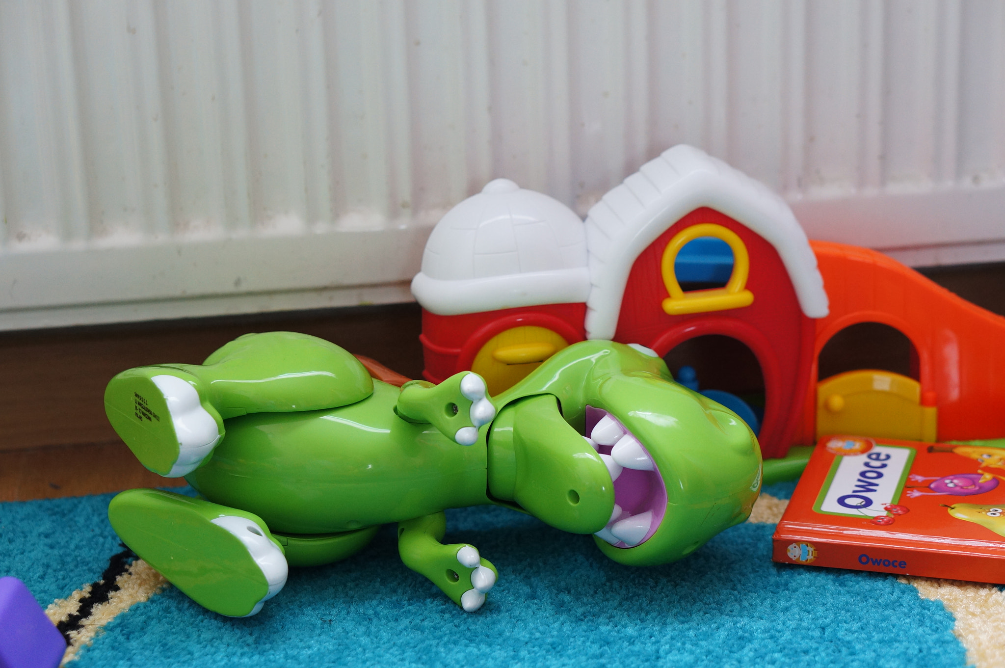 Sony Alpha NEX-5N + Sony E 50mm F1.8 OSS sample photo. Poznan poland - august 02, 2015: green toy dinosaur lying on the floor photography