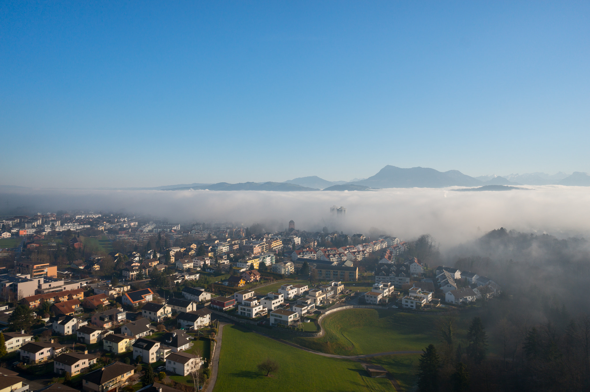 Sony Alpha NEX-5T + Sony E 16mm F2.8 sample photo. Village vanishes in rising fog photography