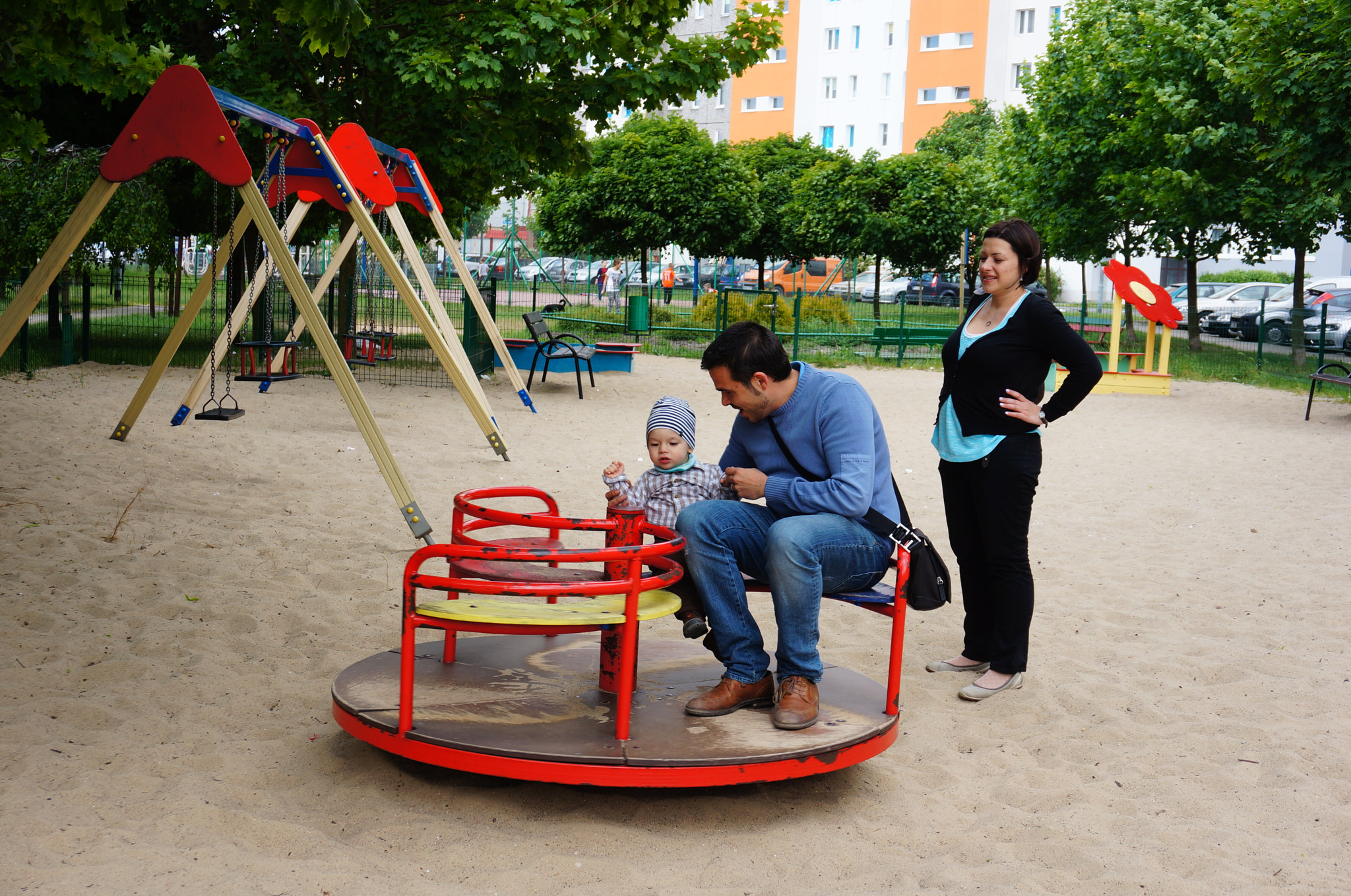 Sony Alpha NEX-5N + Sony E 18-50mm F4-5.6 sample photo. Man and child on roundabout photography