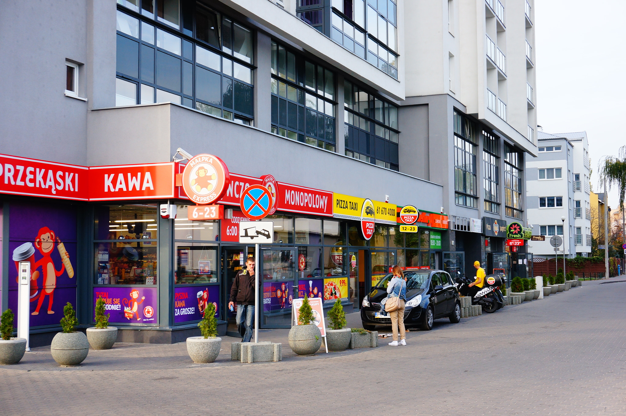 Sony Alpha NEX-5N + Sony E 18-50mm F4-5.6 sample photo. Poznan, poland - october 23, 2013:  row of small shops and restaurants at the rataje bus station photography