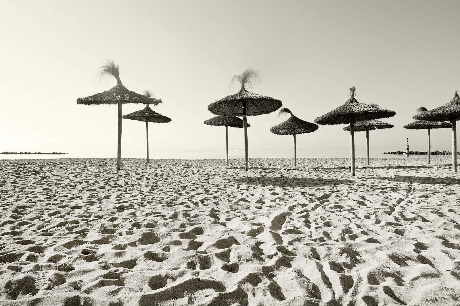 Nikon D7100 + AF Nikkor 24mm f/2.8 sample photo. Straw parasols on sandy beach photography