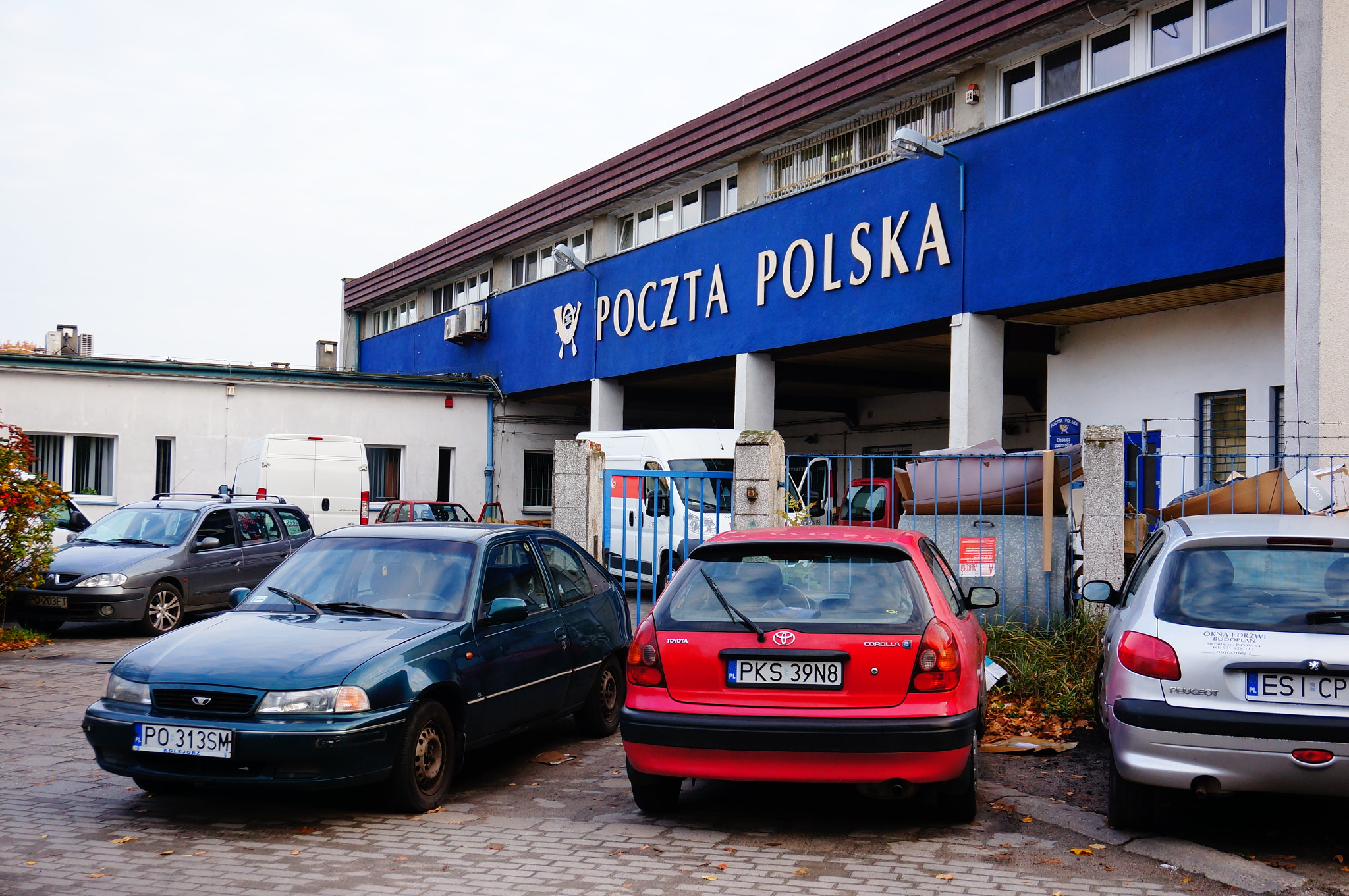 Sony Alpha NEX-5N + Sony E 16-50mm F3.5-5.6 PZ OSS sample photo. Poznan, poland - october 16, 2013: parked cars in front of a post office photography