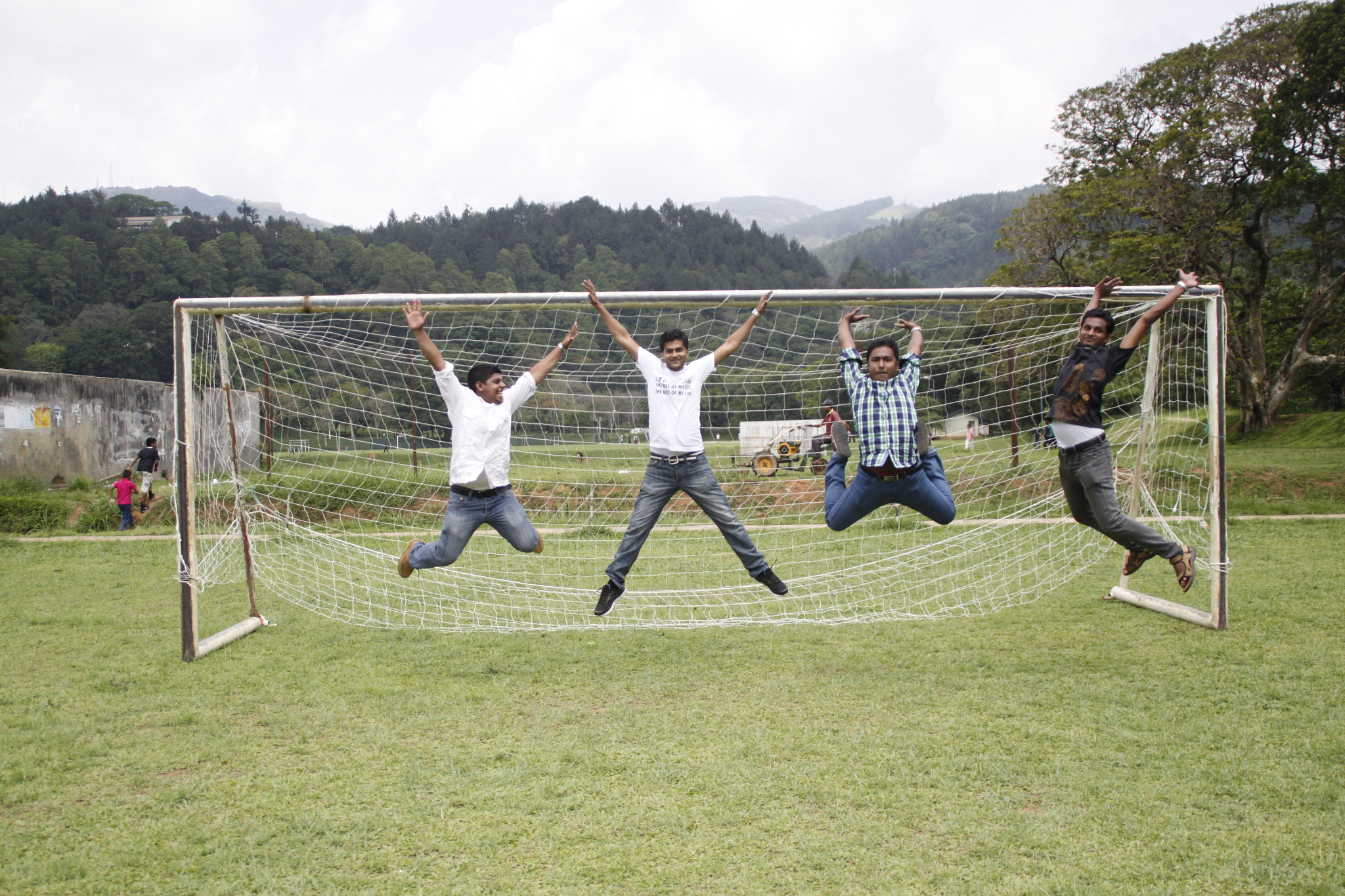 Canon EOS 500D (EOS Rebel T1i / EOS Kiss X3) sample photo. Four boys jumping to sky near a football photography