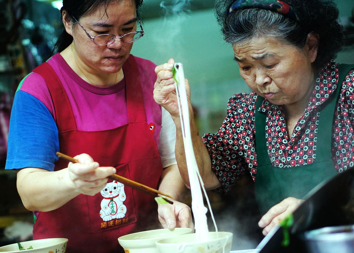 Sony Alpha NEX-5N + Sony E 50mm F1.8 OSS sample photo. Noodles soup women  photography