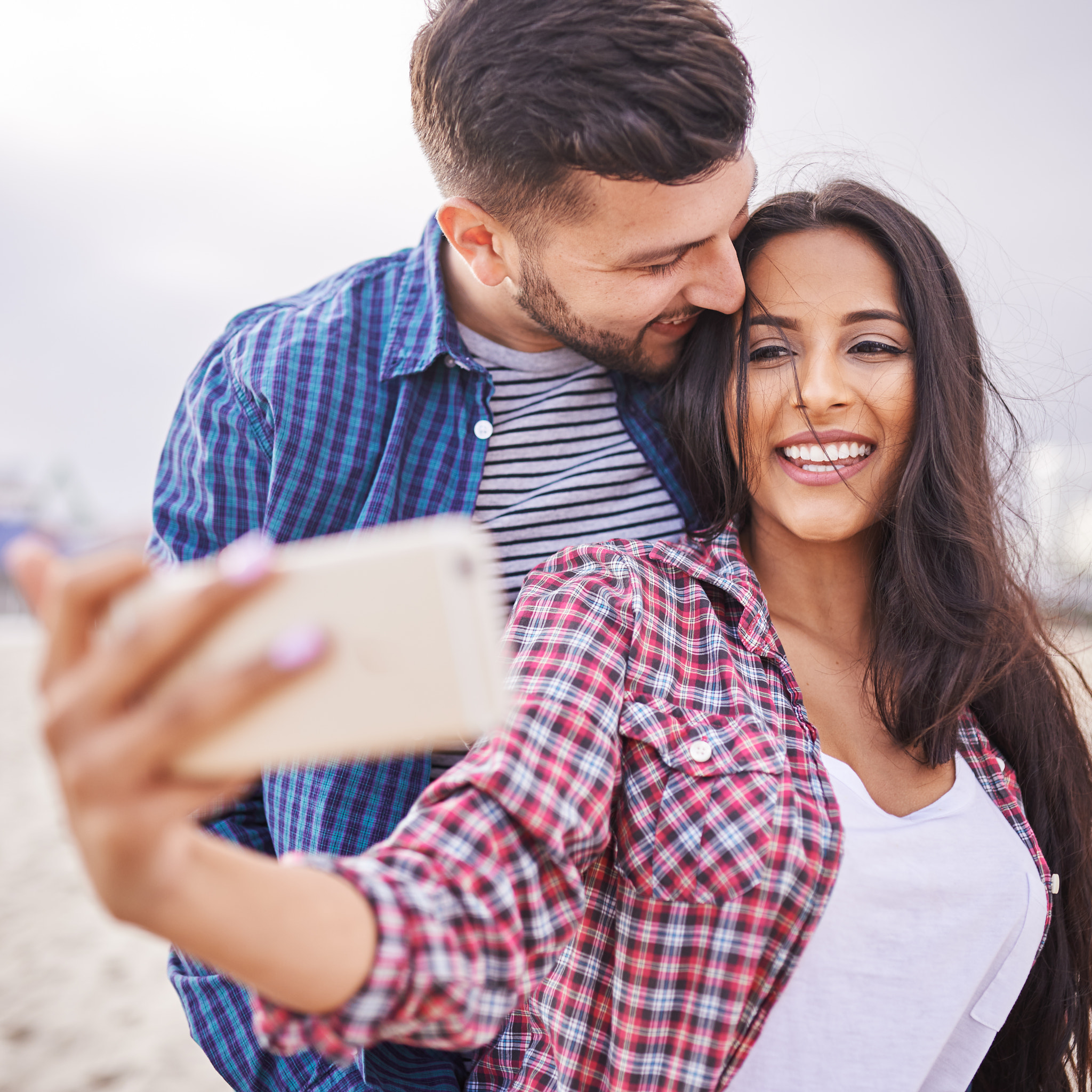 playful romantic couple taking selfies together