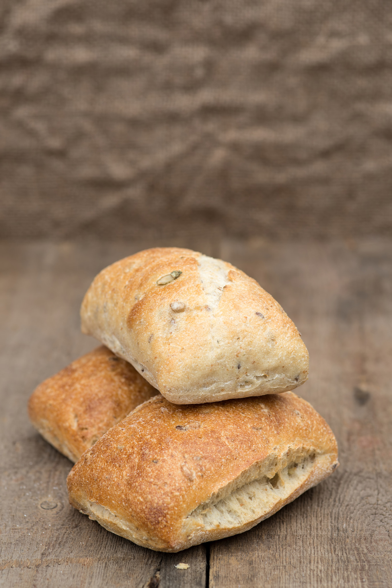 Nikon D600 + Sigma 105mm F2.8 EX DG Macro sample photo. Olive bread rollis in rustic kitchen setting with utensils photography
